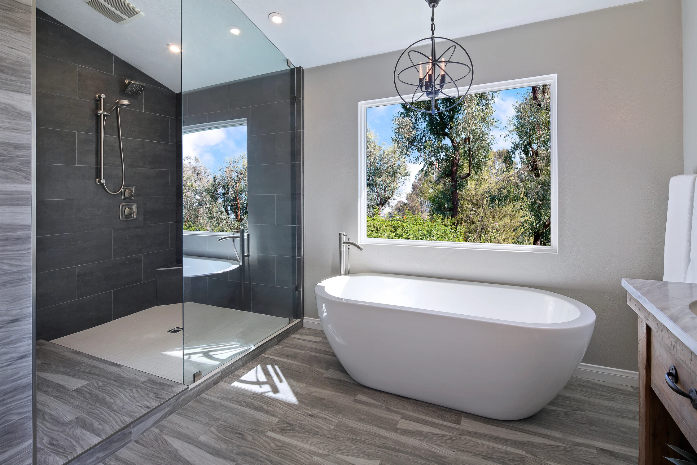 Master bathroom with freestanding tub and black tiled shower