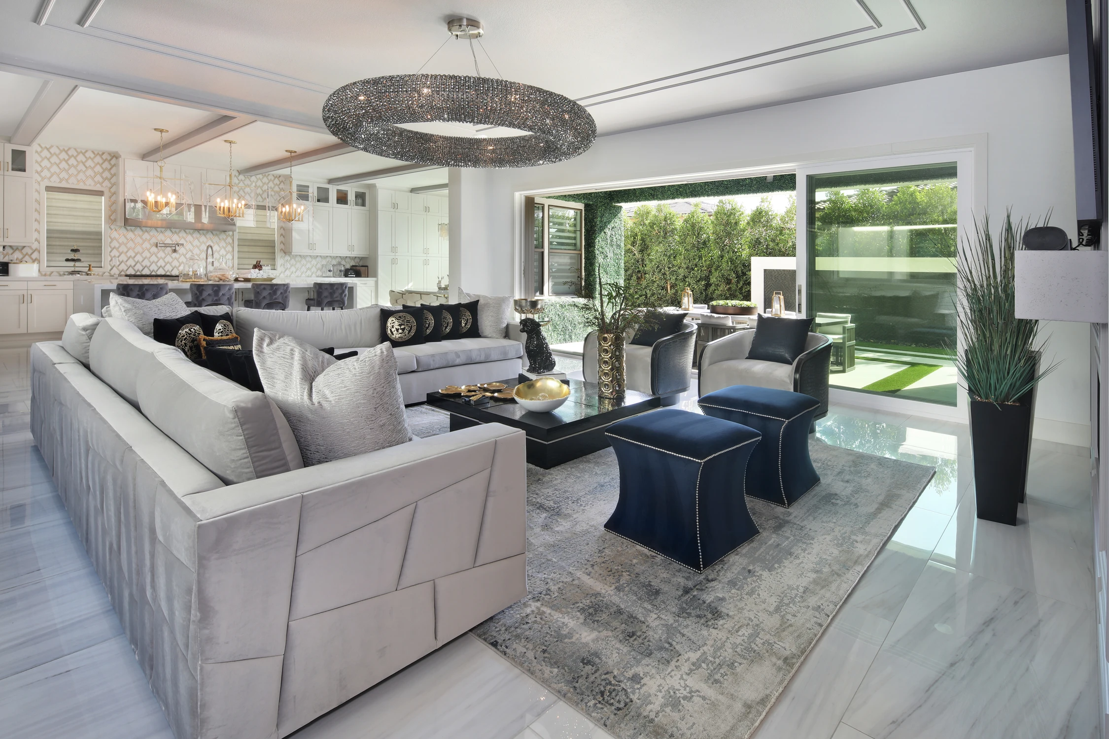 Living room with white sectional, blue chairs, and open patio doors