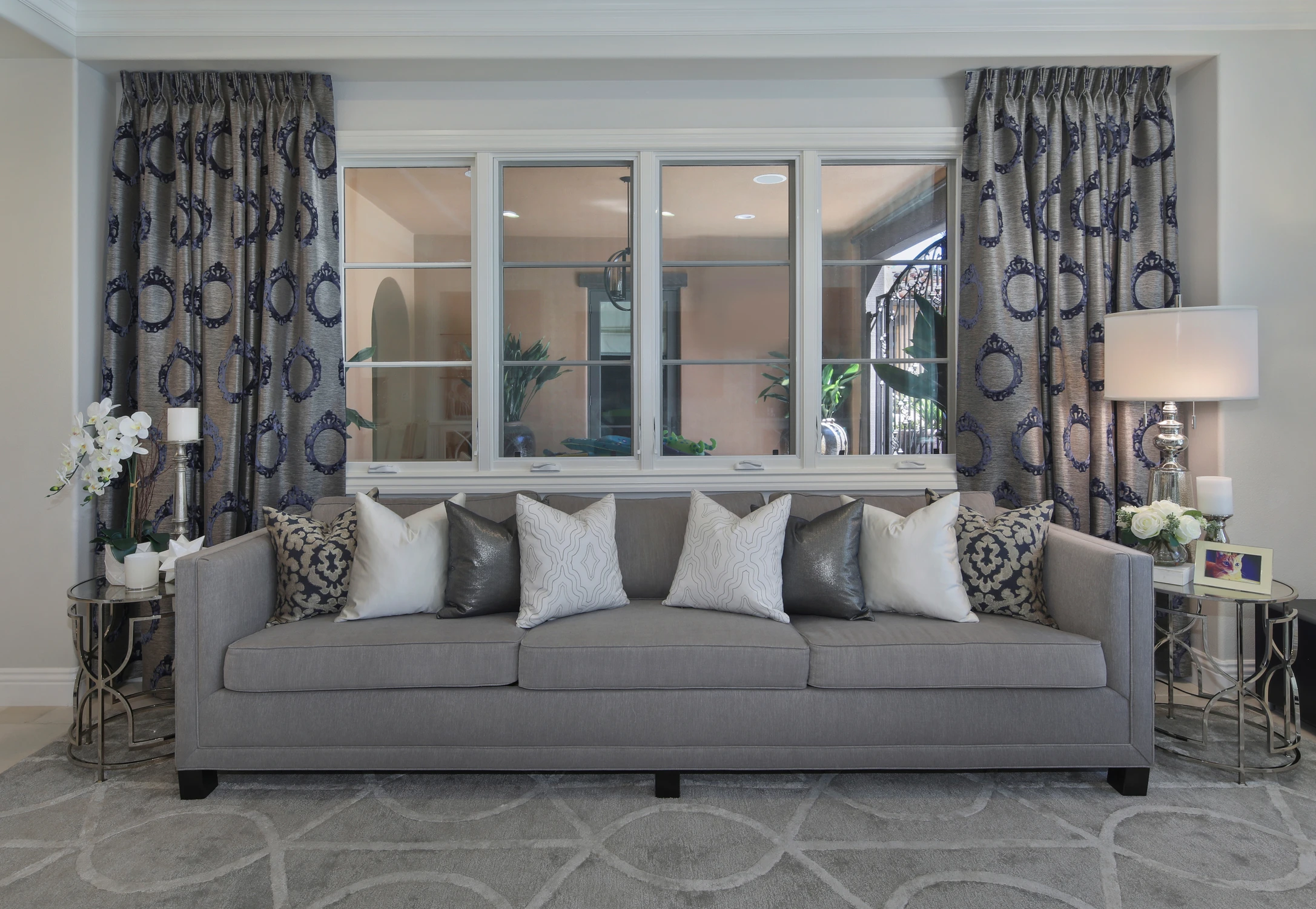 Living room with gray sofa, patterned drapery, and window bench