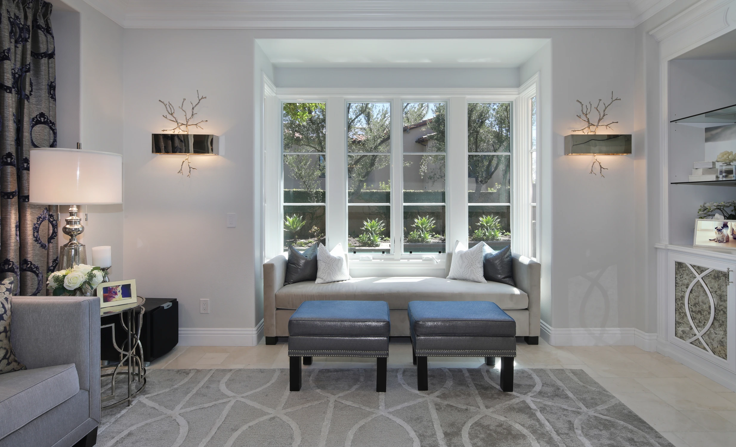 Living room window bench with gray upholstery and matching ottomans