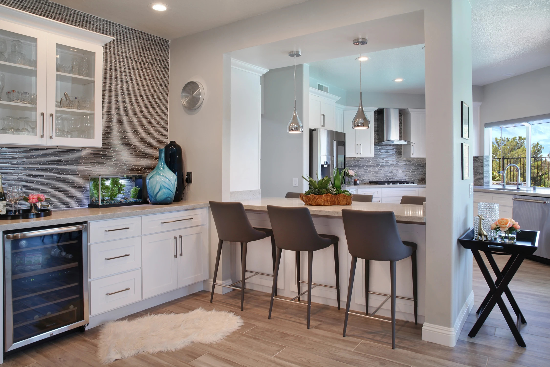 Kitchen beverage station with glass cabinetry and stone backsplash