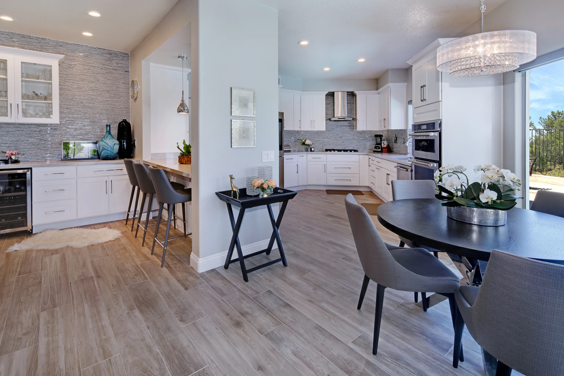 White kitchen with central island, stainless appliances, and wood flooring