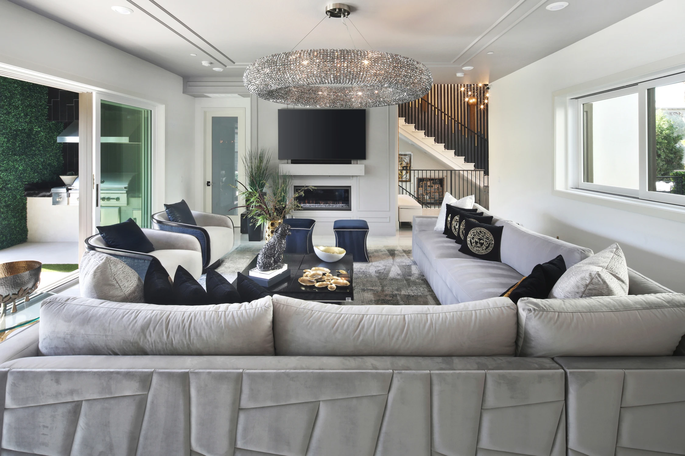 Living room with white sectional beneath a crystal chandelier