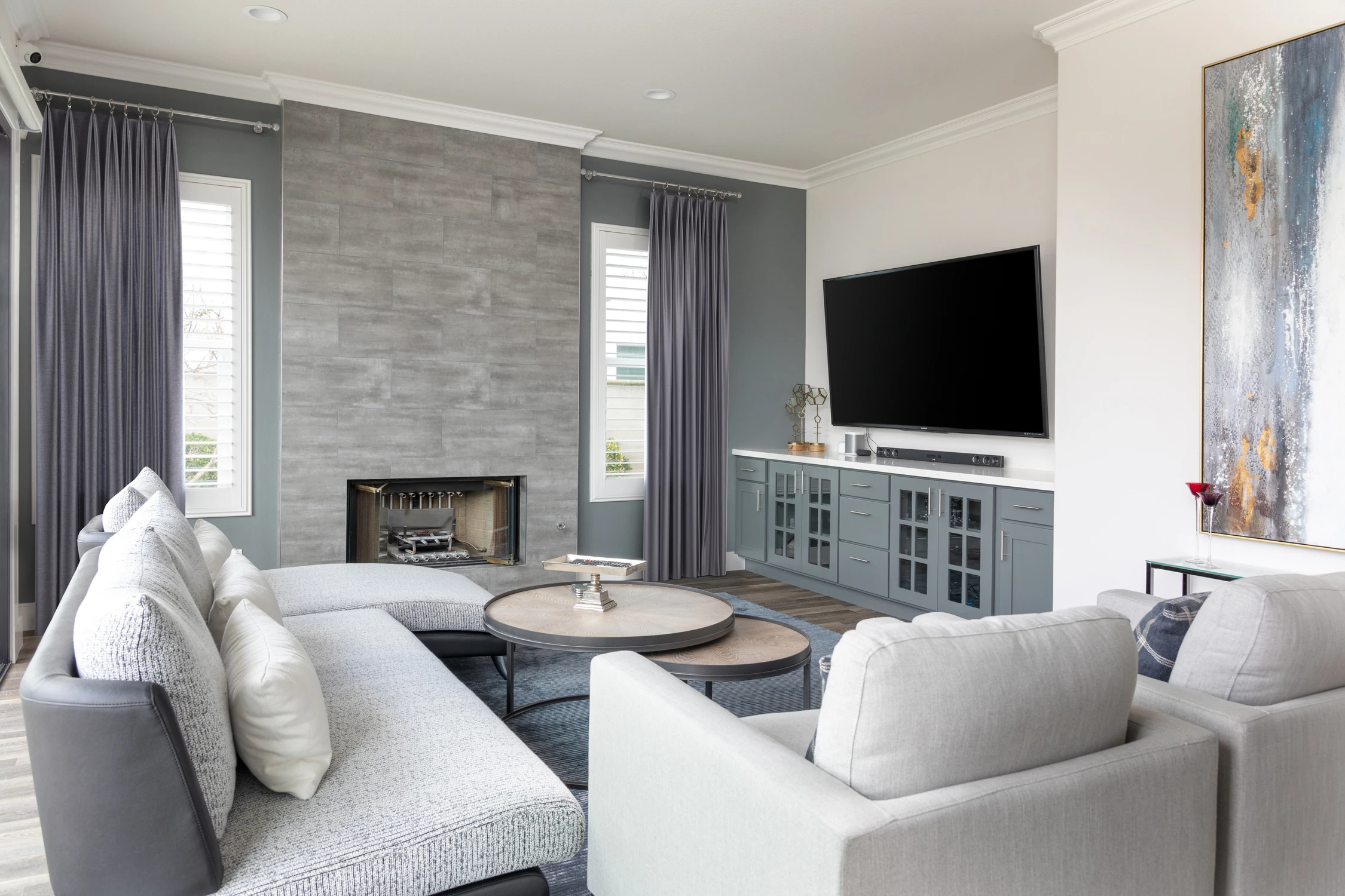 Family room seating facing a tiled fireplace and wall-mounted television