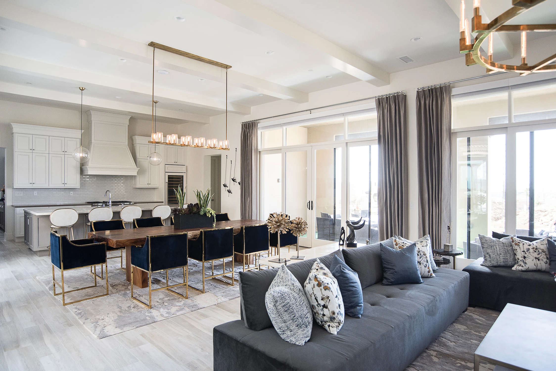 Open living and dining space with gray sectional and navy chairs