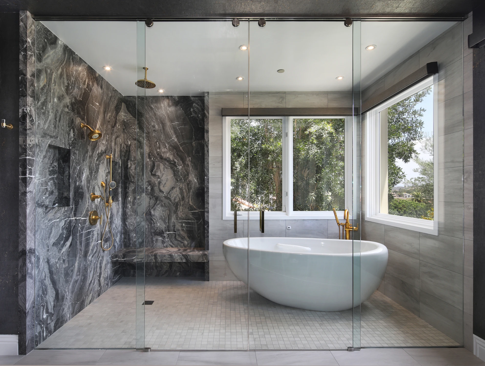 Bathroom with freestanding tub, marble shower, and gold fixtures