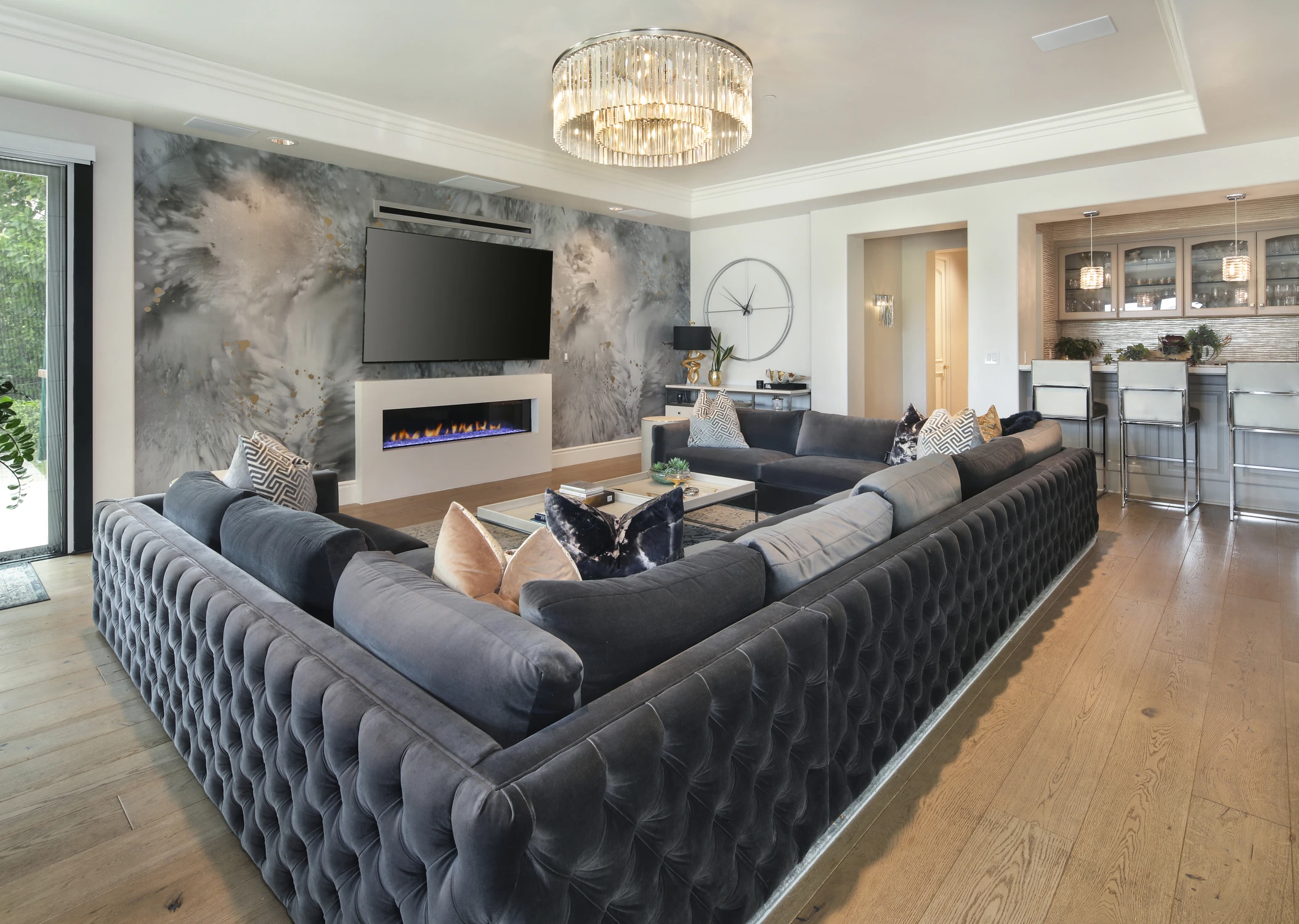 Living room with black tufted sofas, fireplace, and abstract feature wall