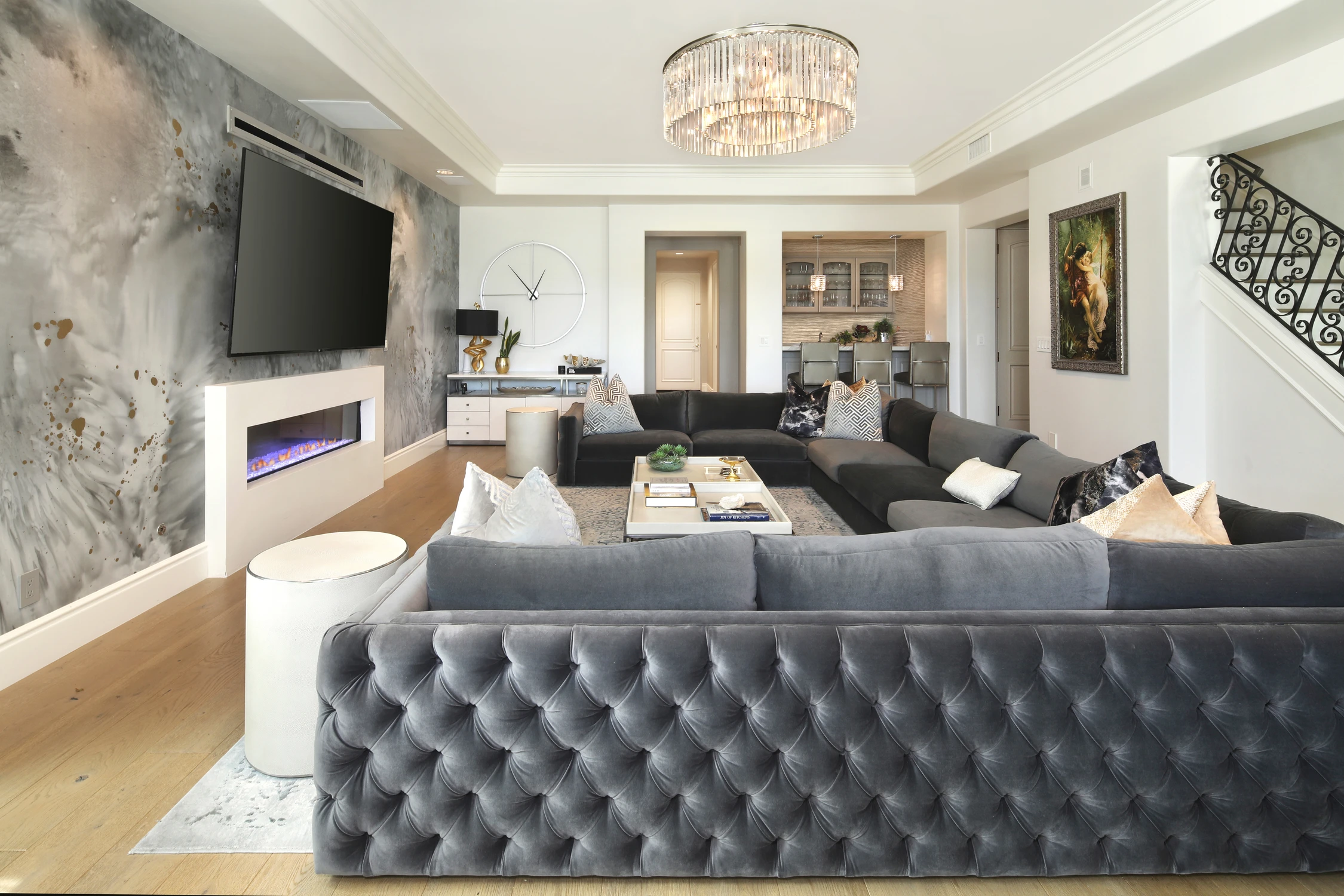 Living room with black sectional, fireplace, and adjoining bar