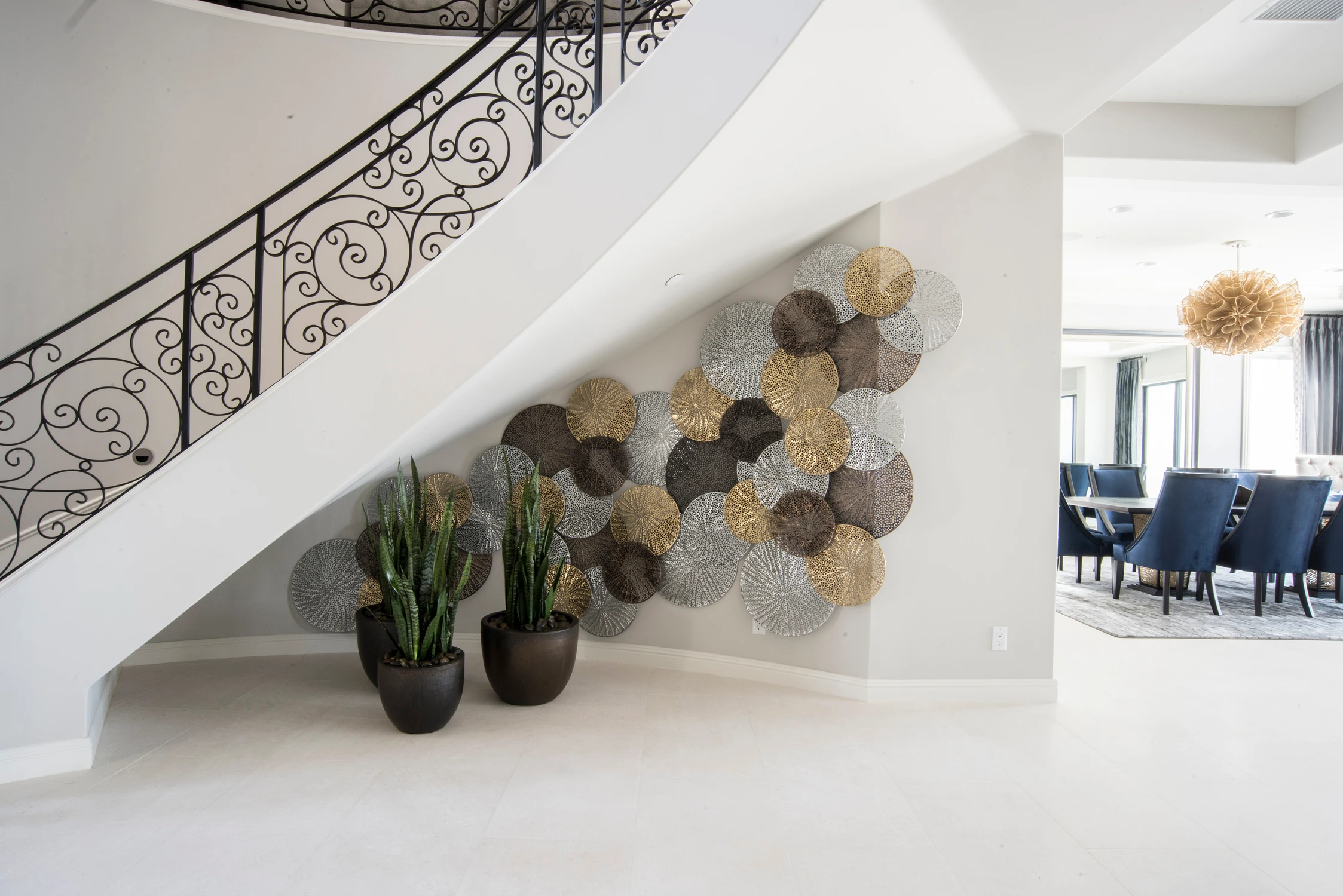 Foyer wall with circular metal artwork and view into dining room