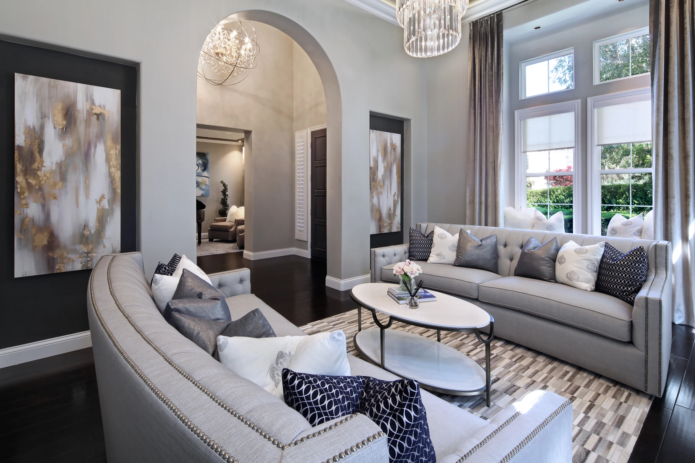 Living room with curved sofa, arched doorway, and dark framed artwork