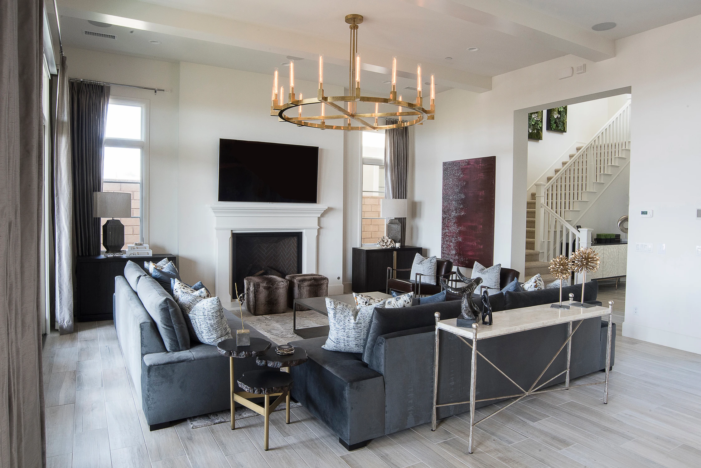 Living room with gray seating beneath a brass chandelier