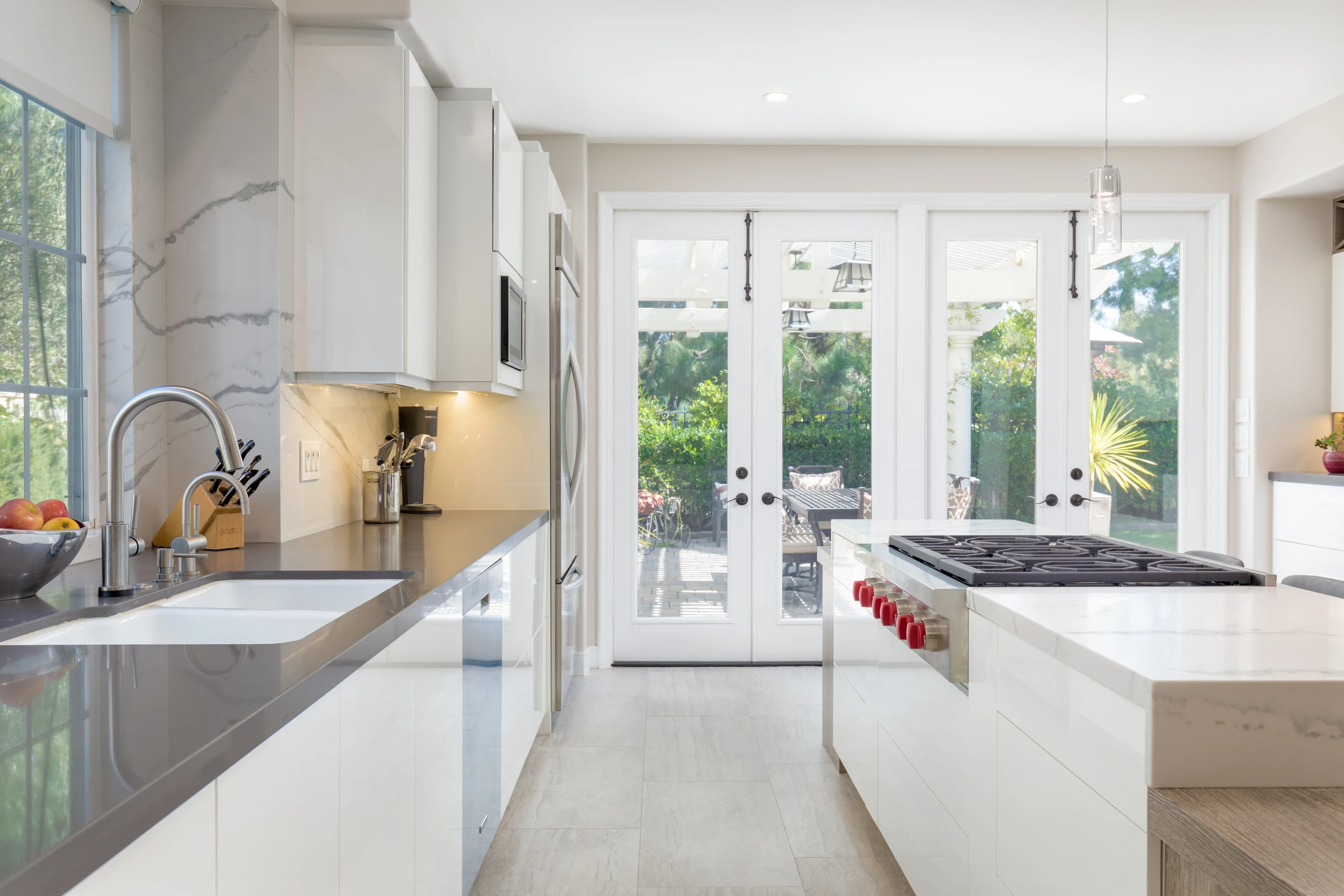 White kitchen with dark counter, large island, and glass rear doors