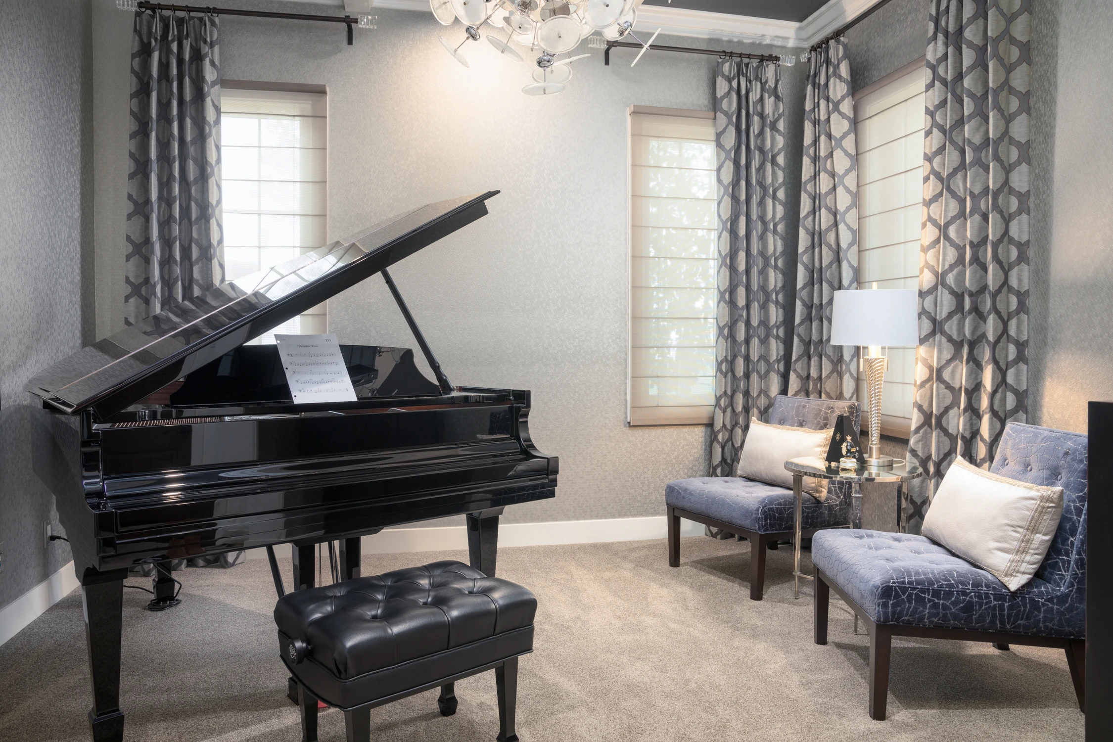 Grand piano with two patterned chairs and gray walls