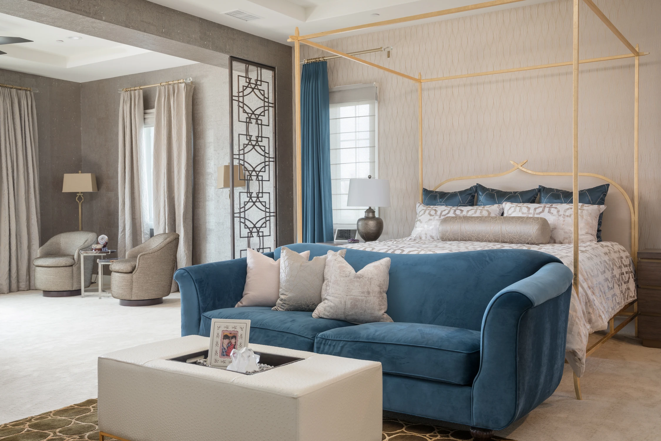 Bedroom with blue velvet sofa, canopy bed, and pale upholstered bench