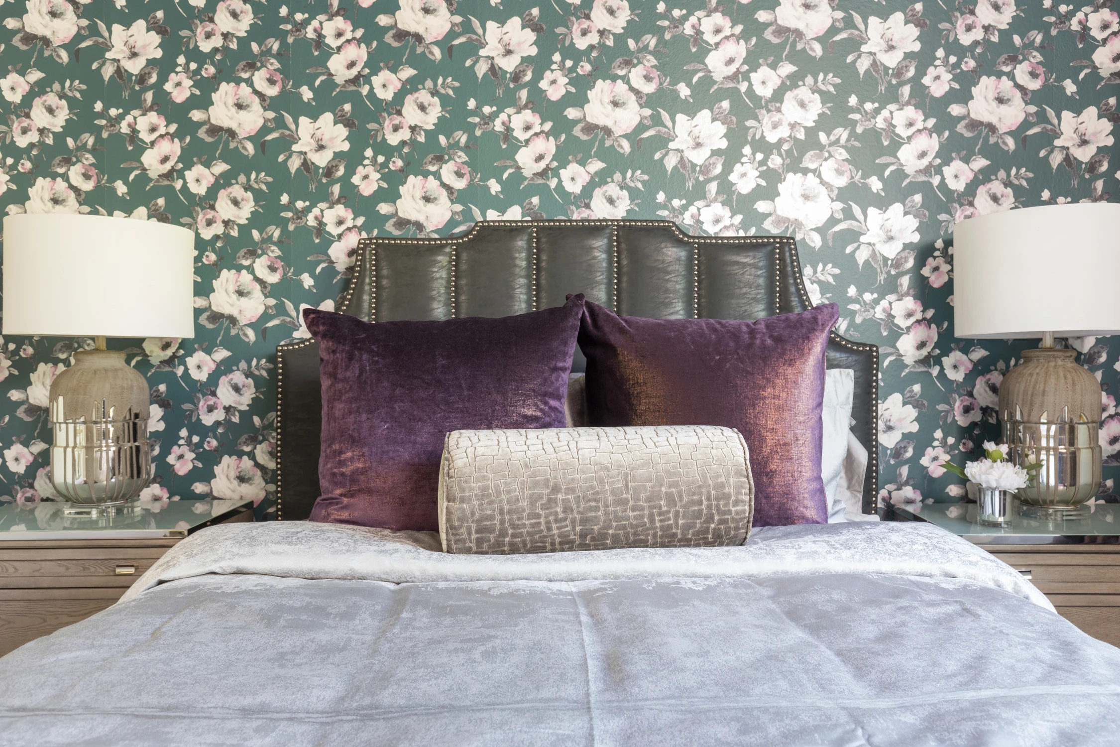 Bedroom with gray upholstered bed and purple accent pillows