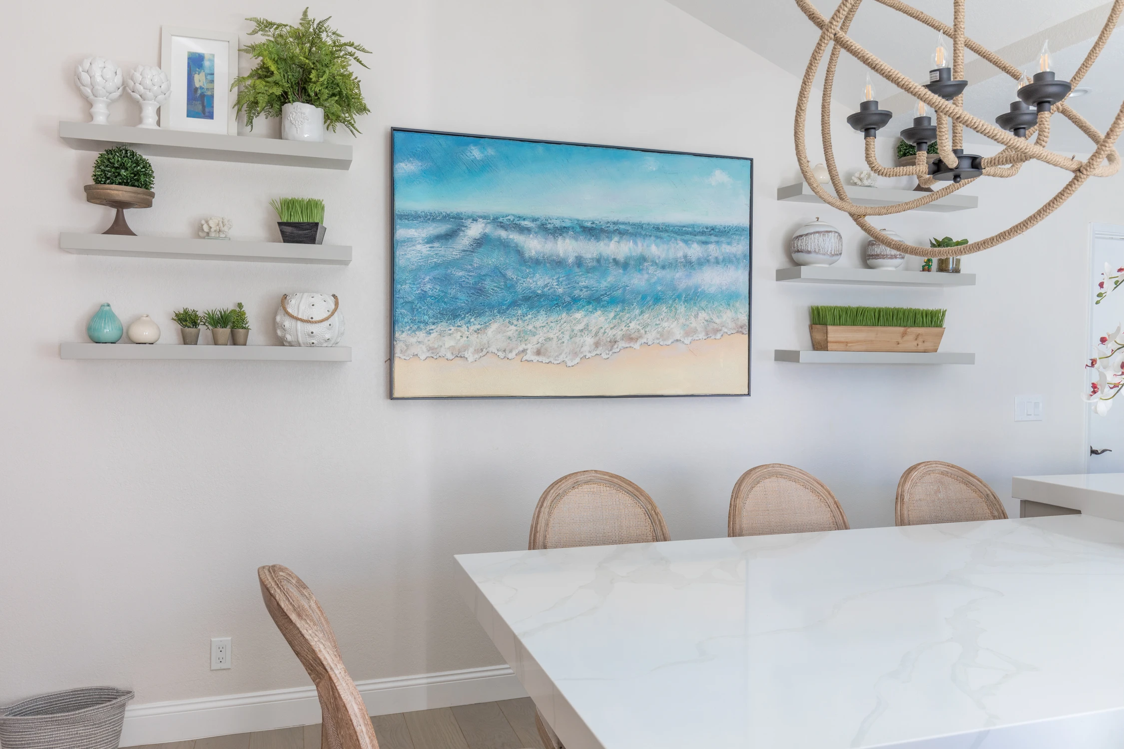 Dining wall with blue landscape art and white floating shelves