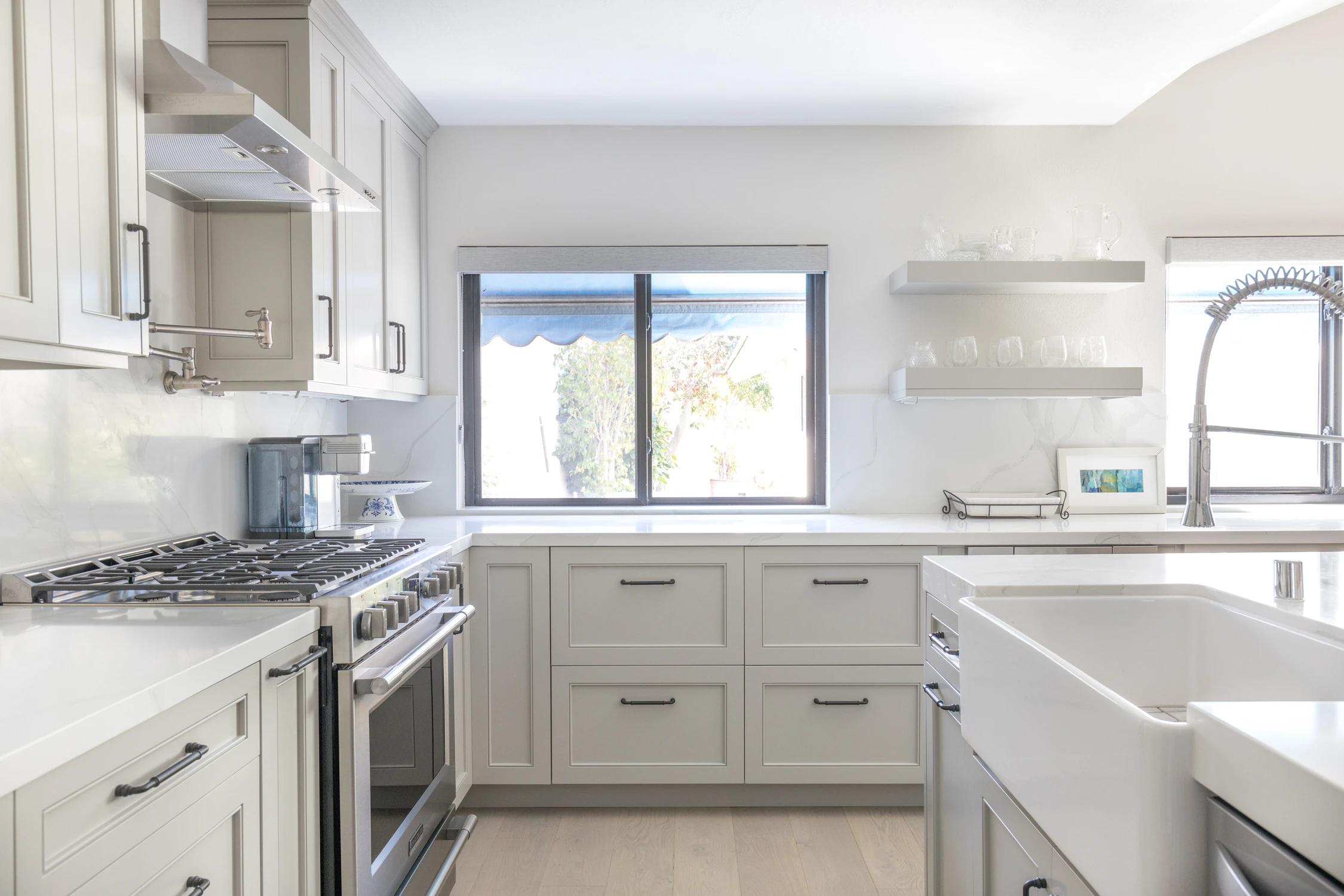 Kitchen with white cabinets, deep sink, and wide rear window