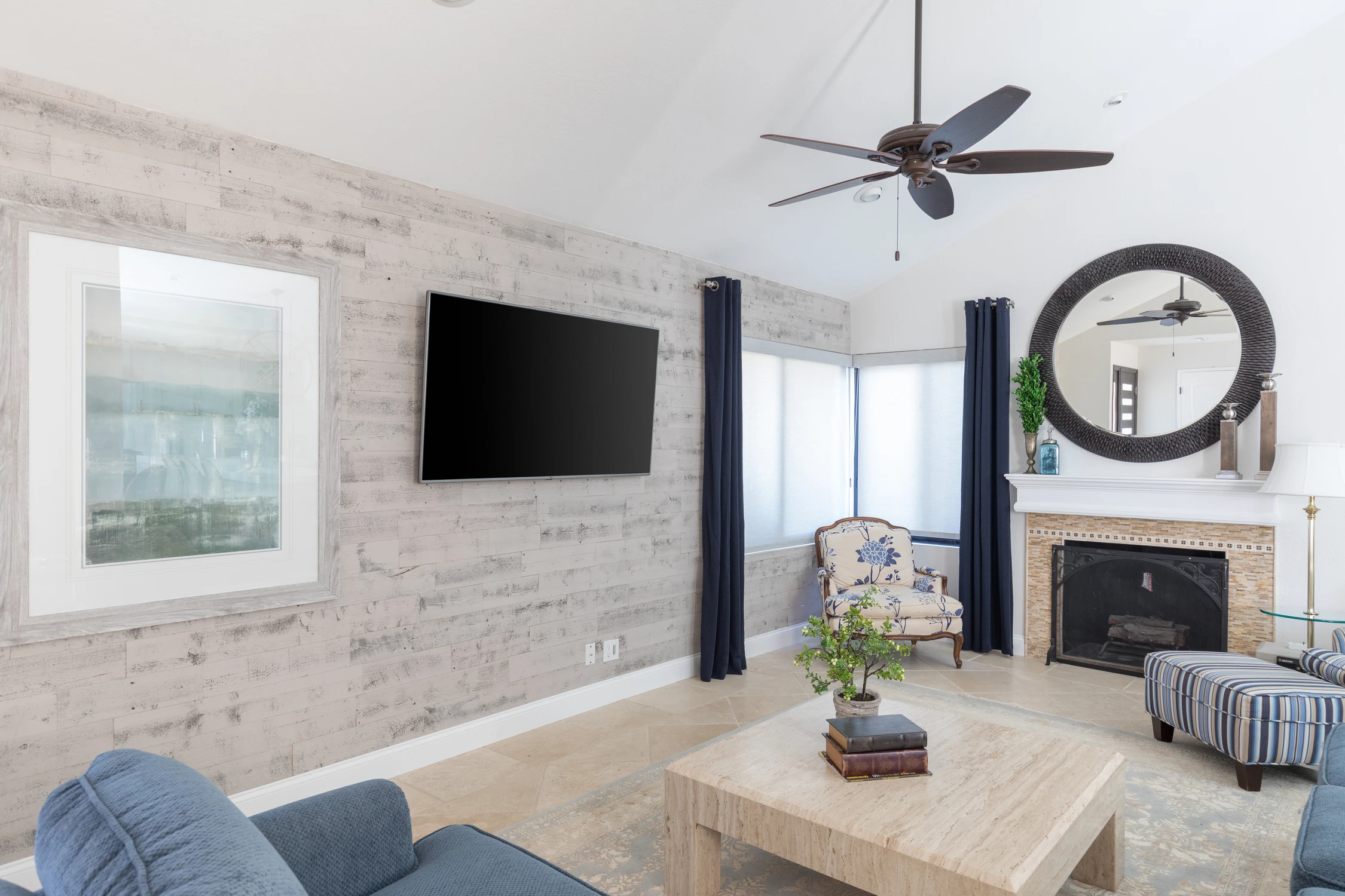 Living room with whitewashed brick television wall, fireplace, and pale seating