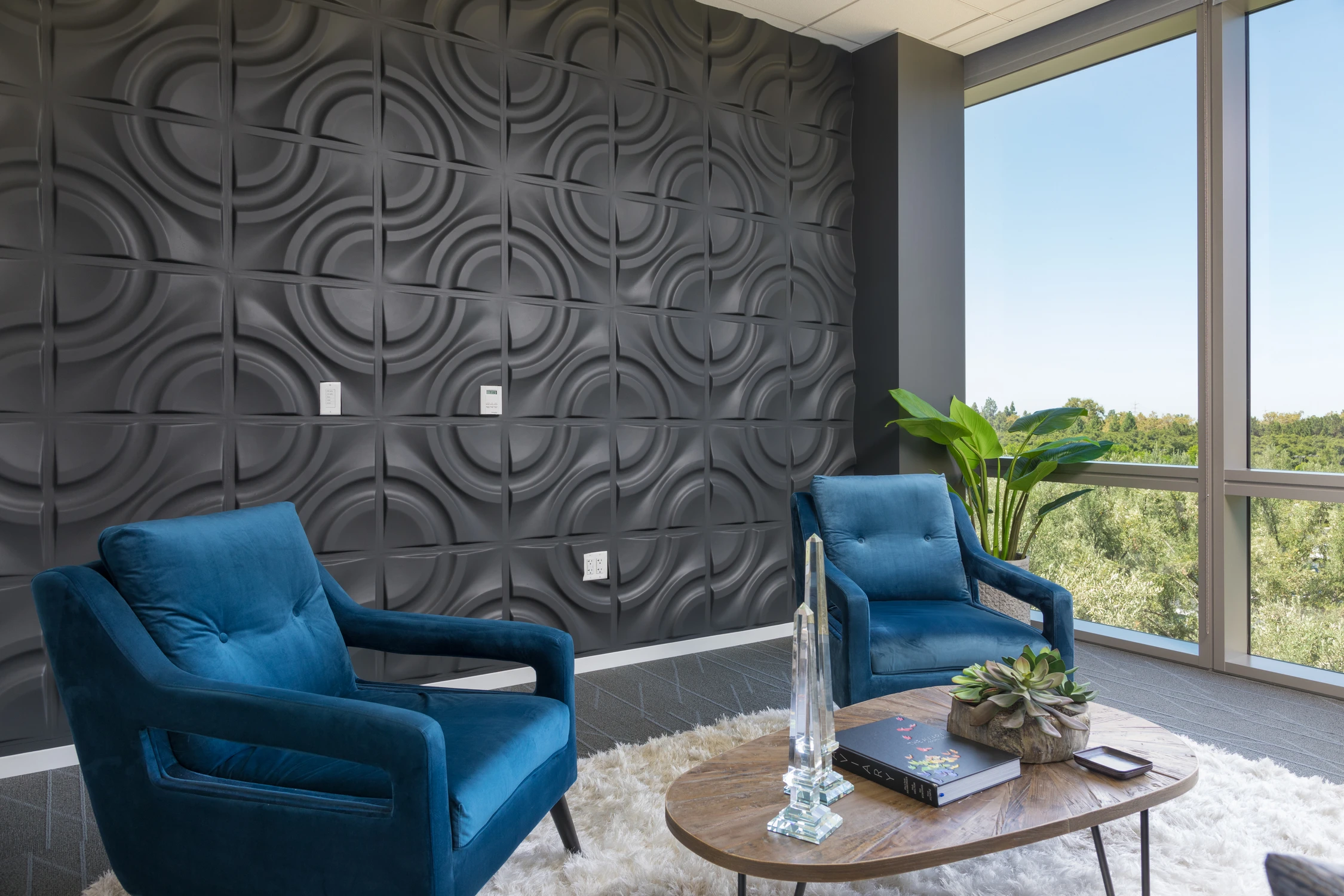 Blue chairs and round table beside floor-to-ceiling office windows