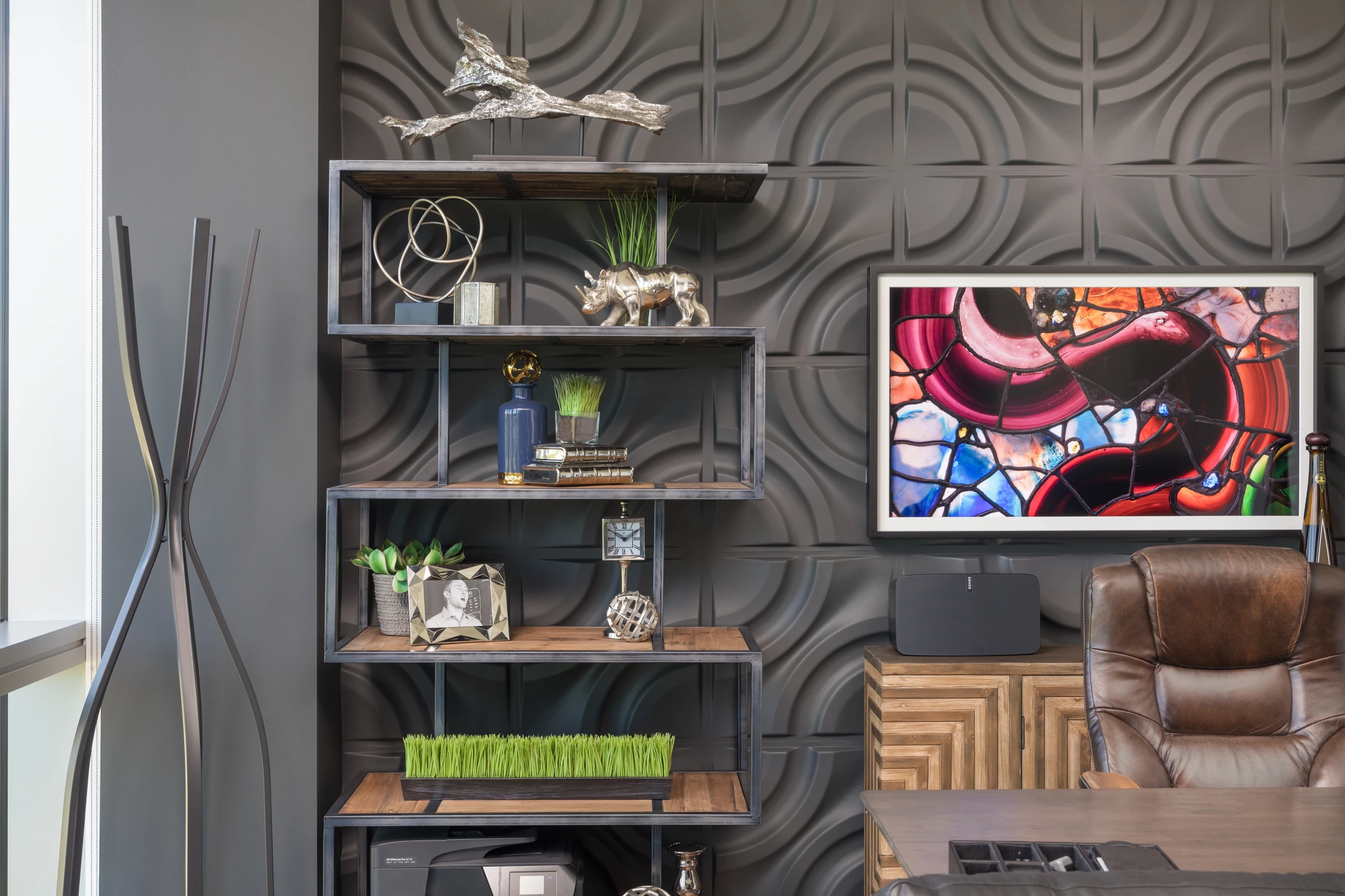 Built-in shelves and colorful artwork above executive desk