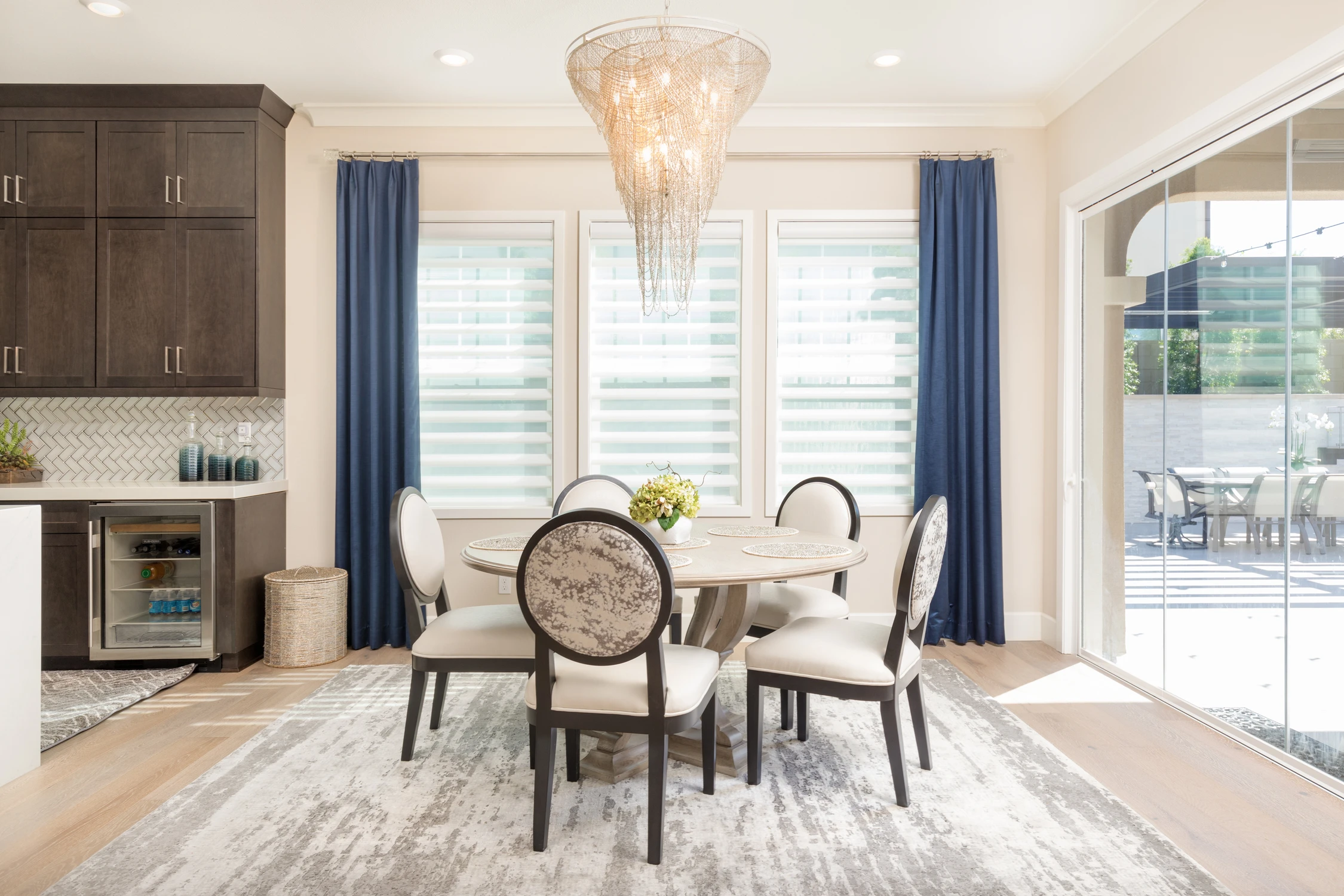 Round dining table with patterned chairs and garden doors