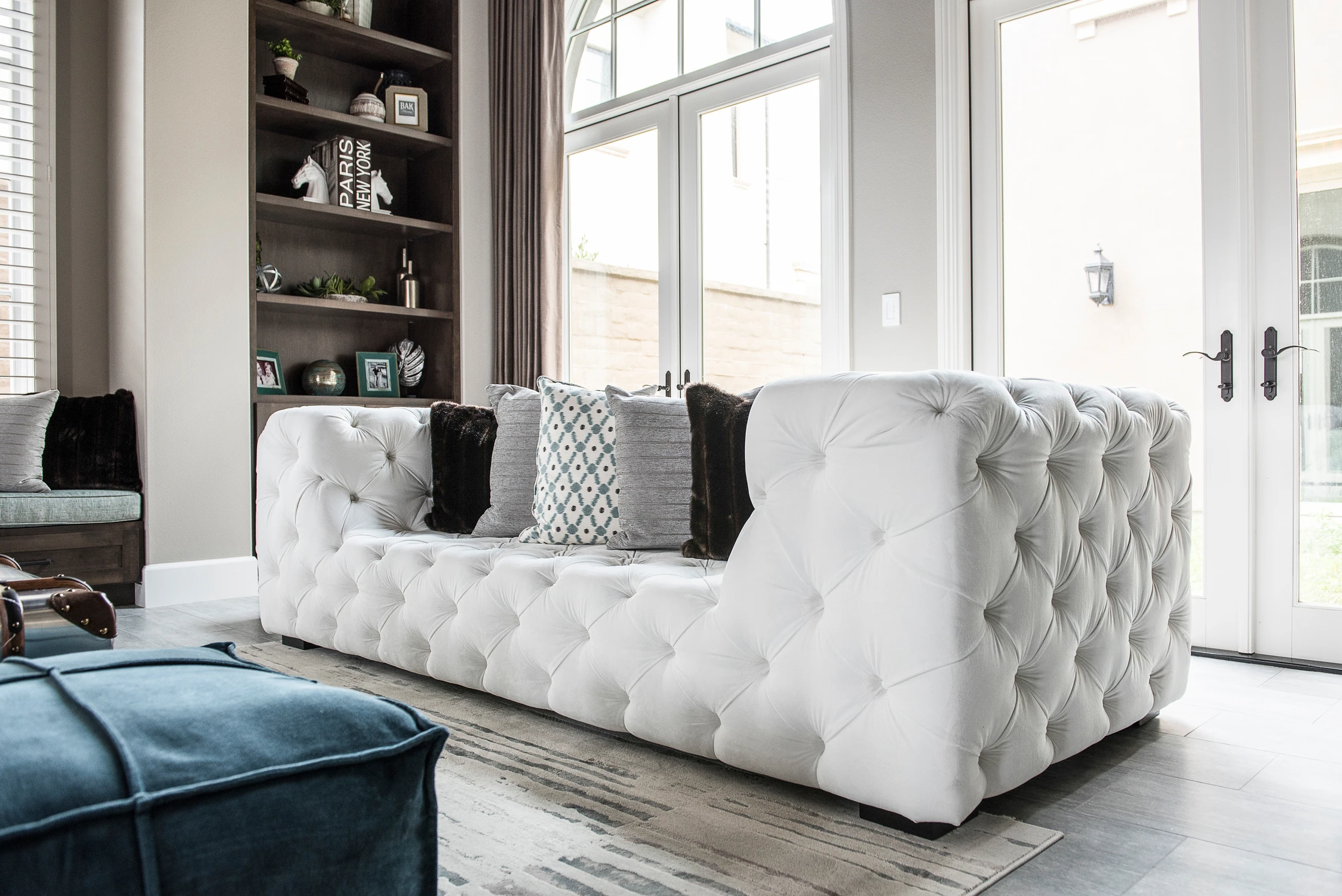 Formal living room with white tufted sofas and arched openings
