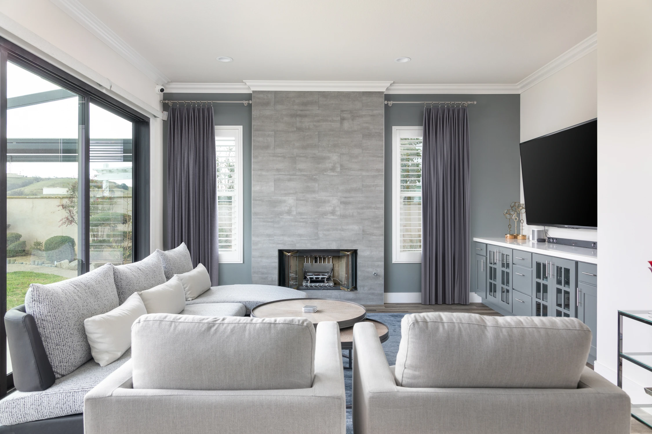 Family room with a tiled fireplace and blue-gray media cabinet