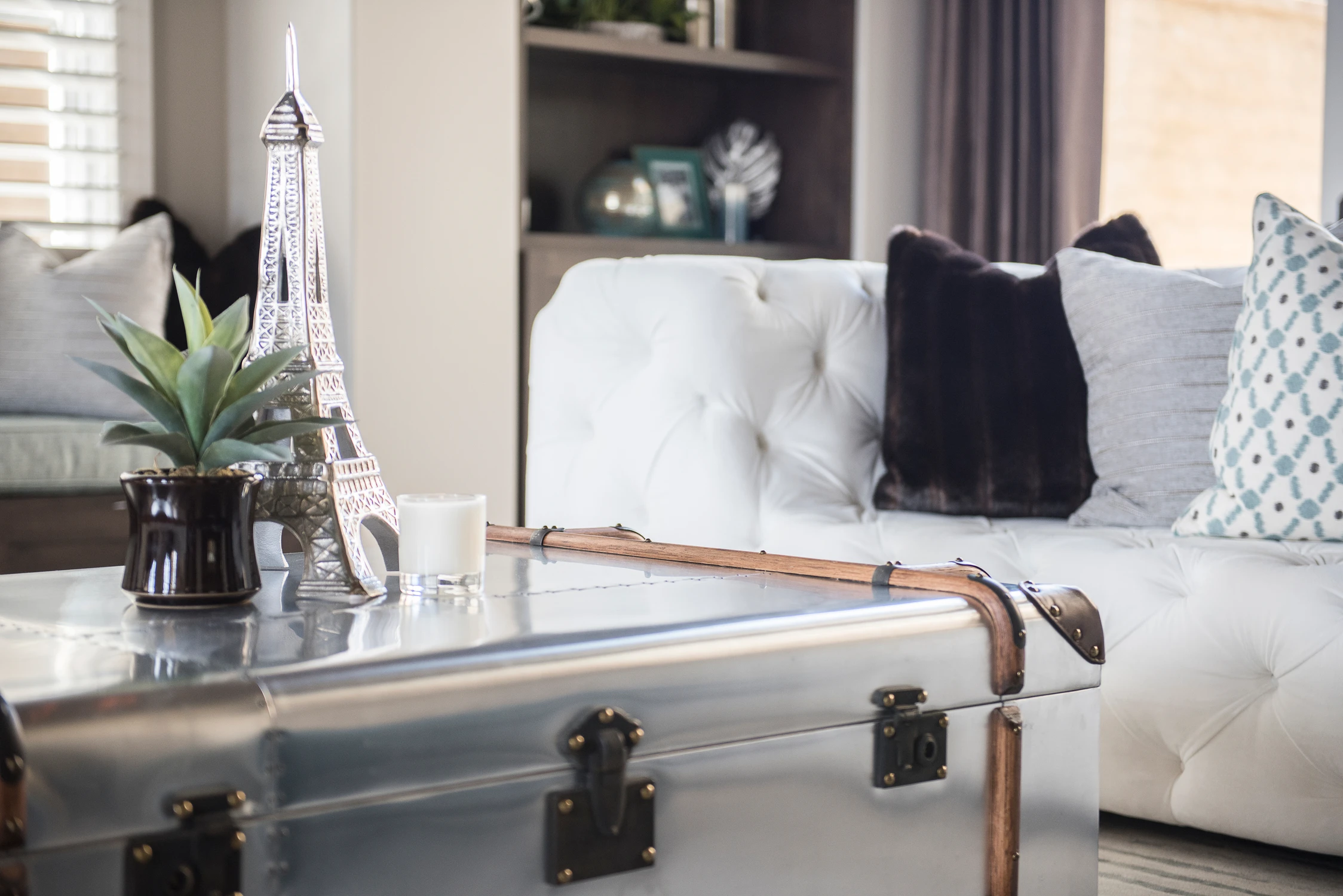 Close view of white tufted sofa and trunk coffee table