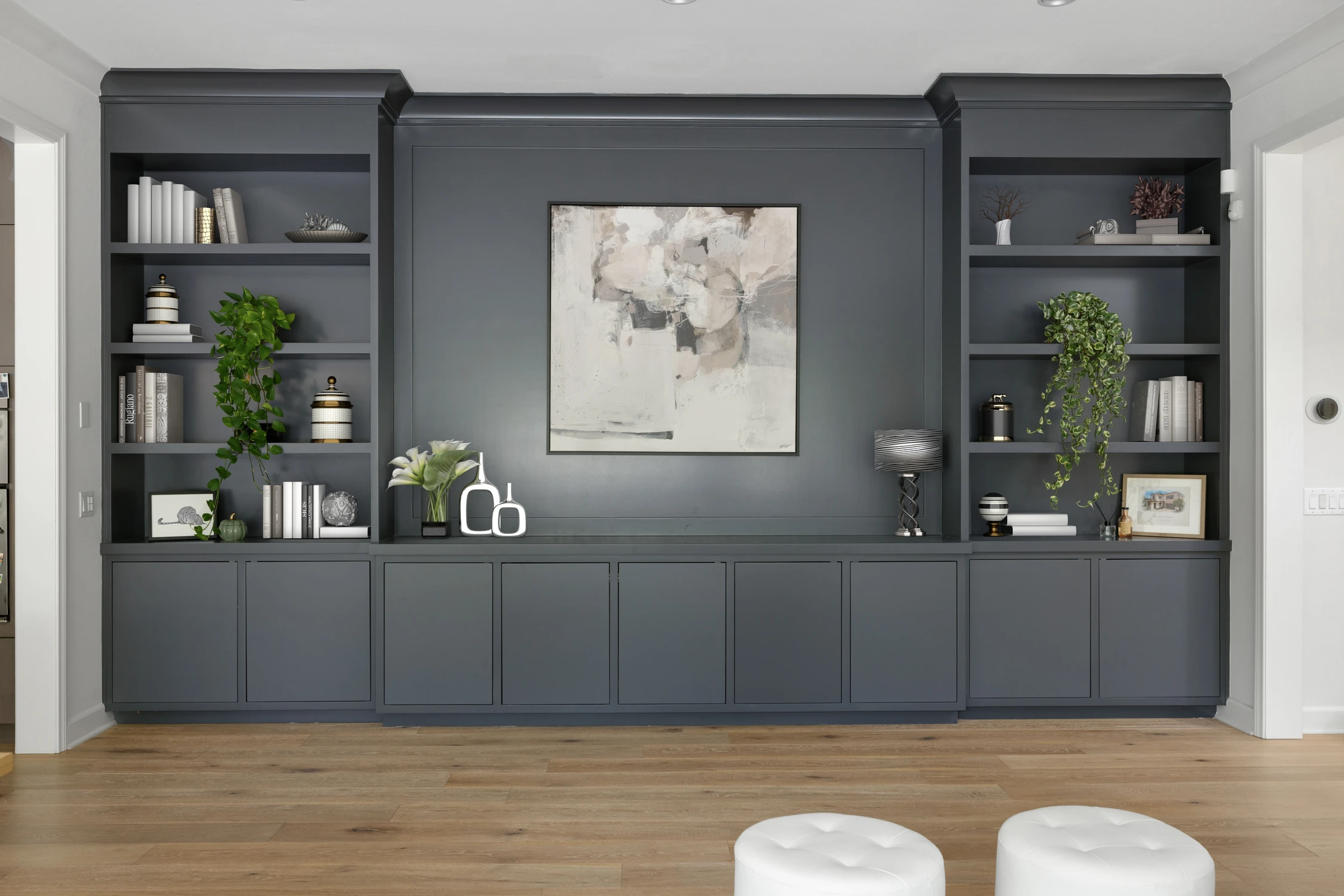 Dark built-in wall with open shelves, framed artwork, and trailing plants
