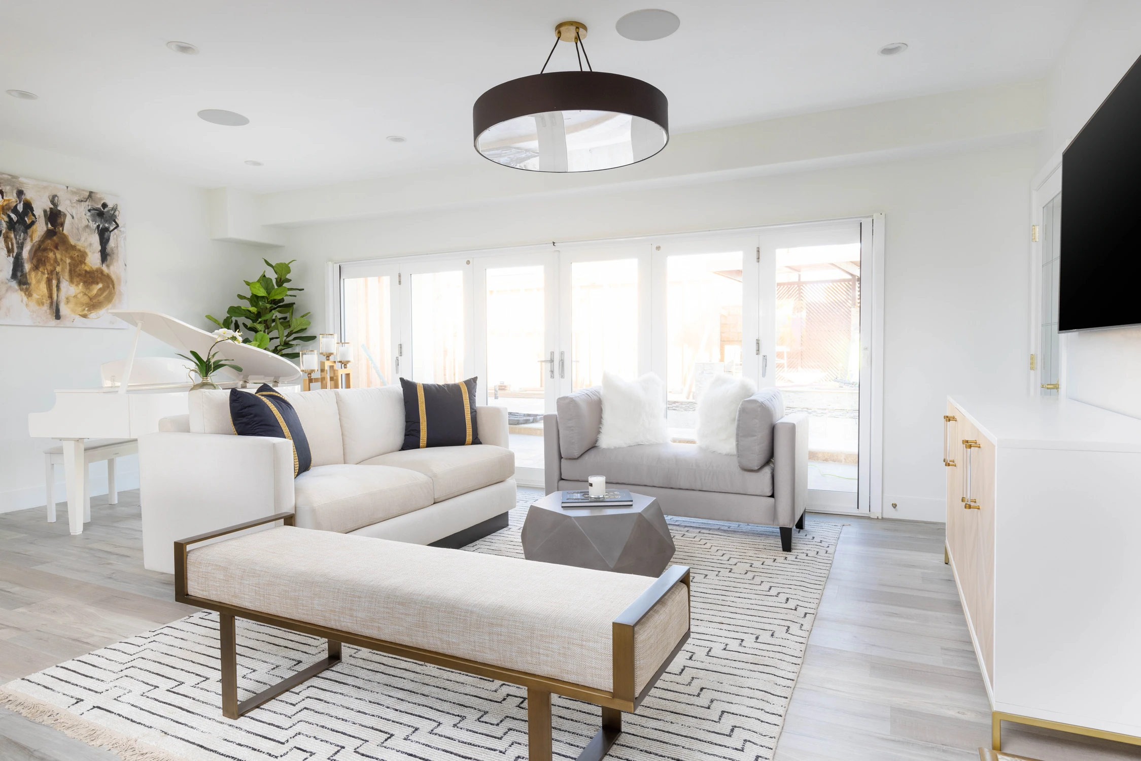 Open living room with white seating and black drum pendant