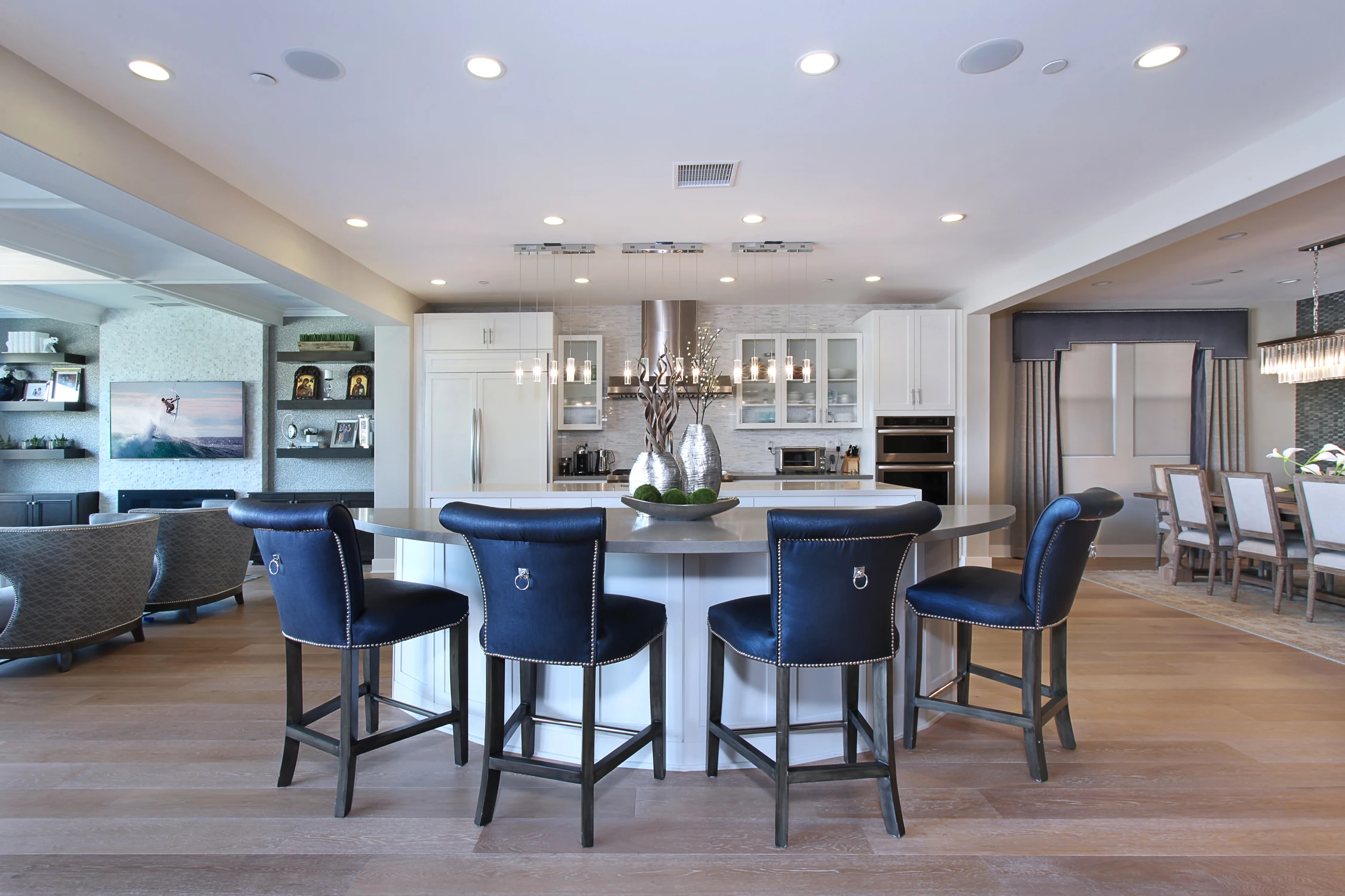 Kitchen island with blue upholstered stools and white cabinetry