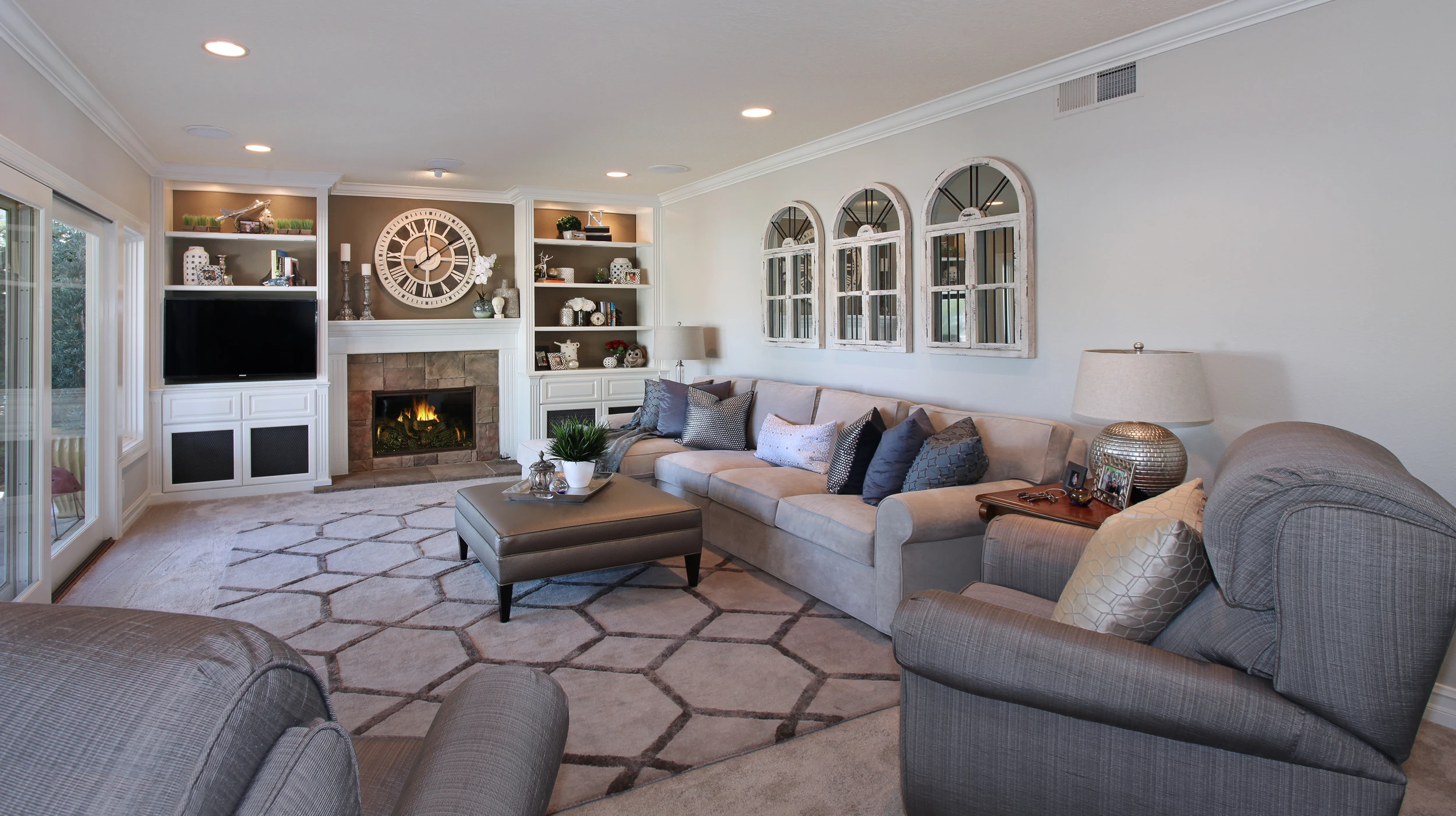 Family room with white built-ins, gray sectional, and patterned area rug
