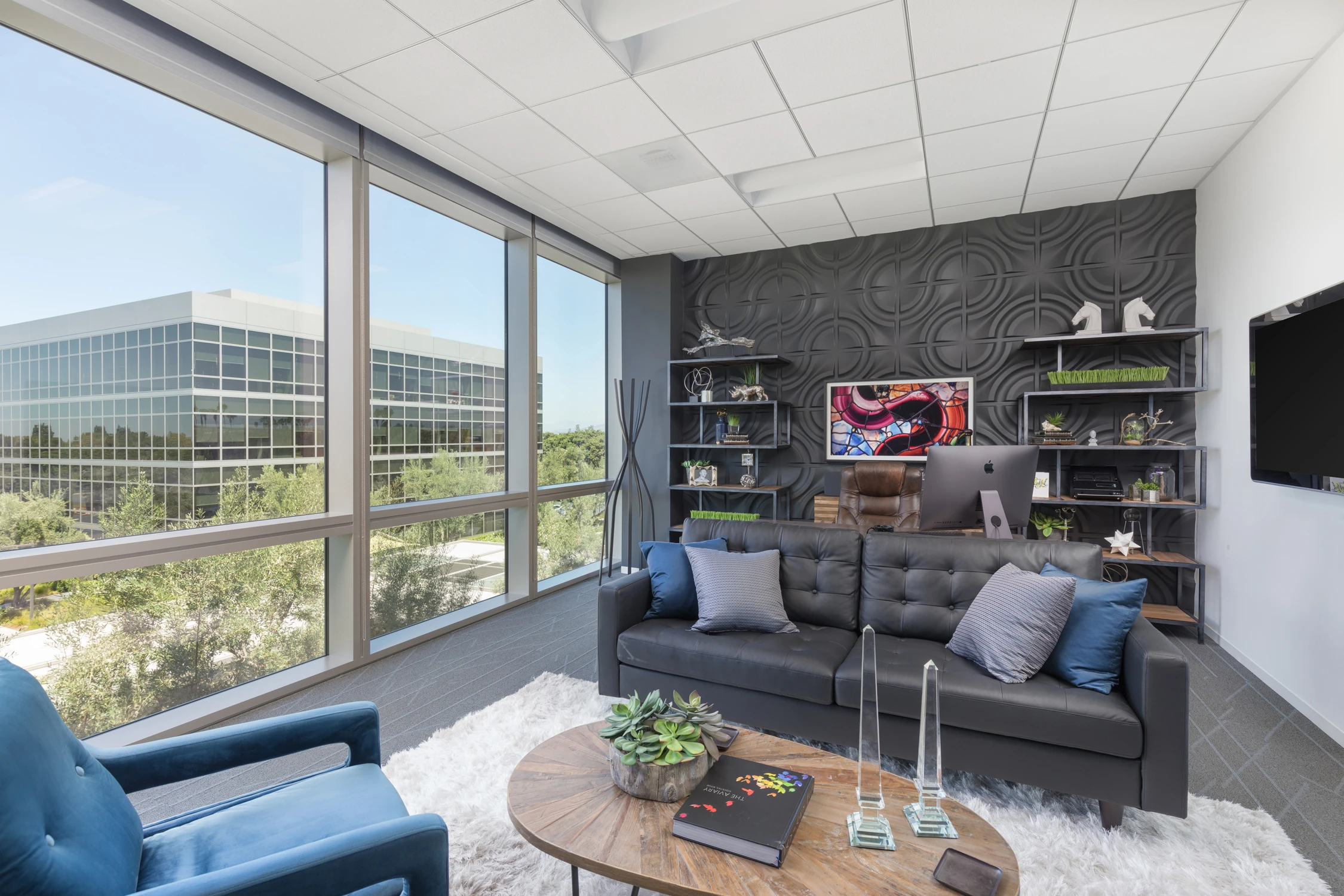Executive office with black feature wall, leather sofa, and city views