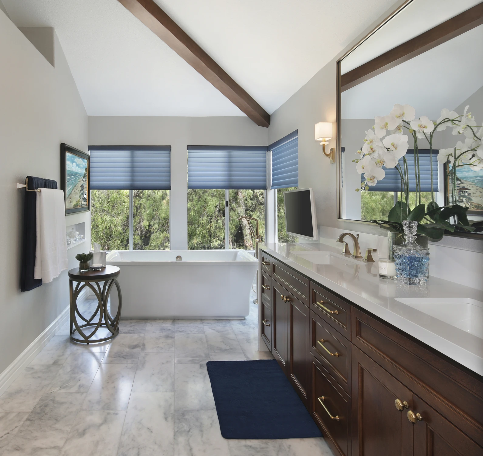 Master bathroom with freestanding tub, dark vanity, and exposed beams