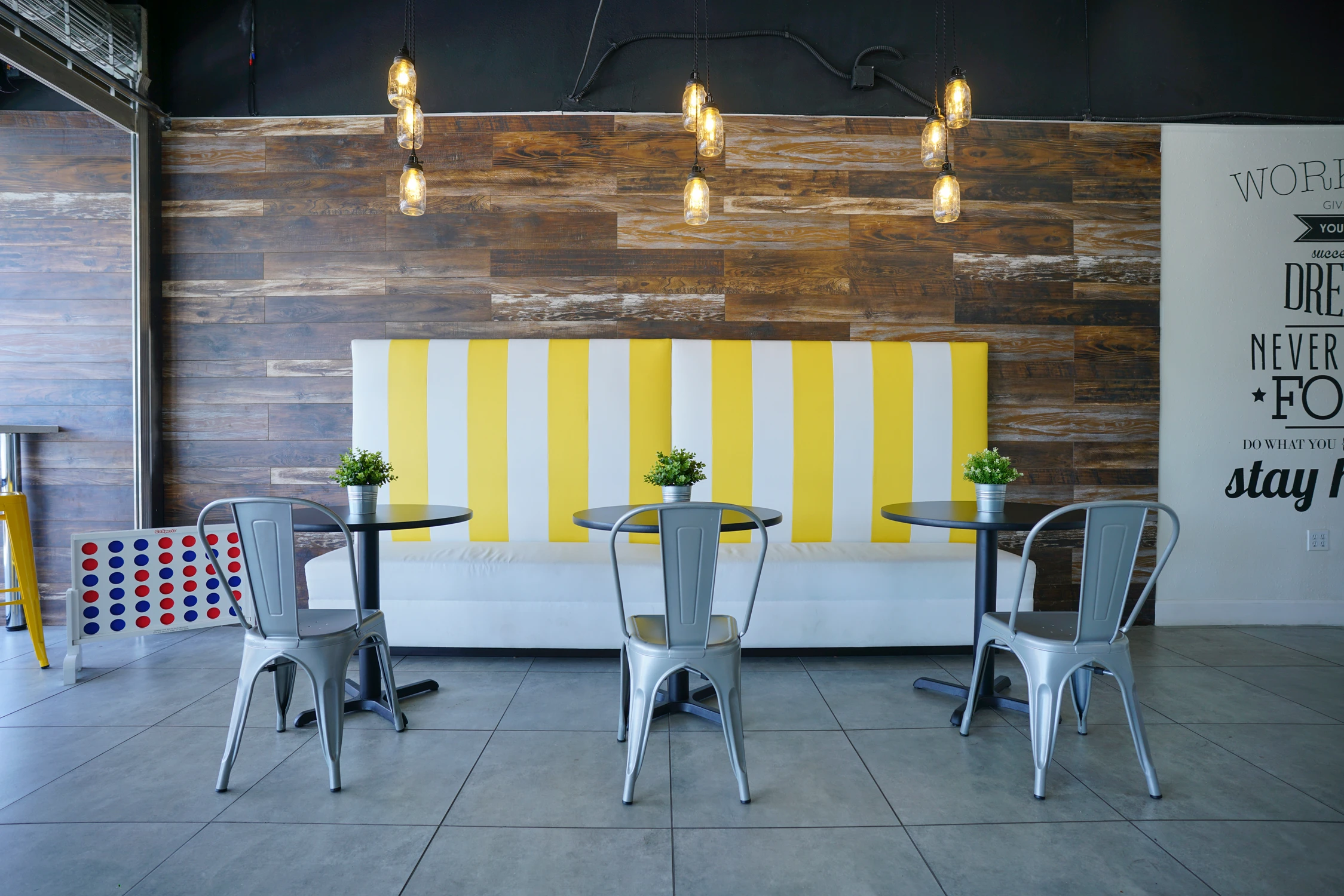 Wide view of striped banquette seating and pendant lights