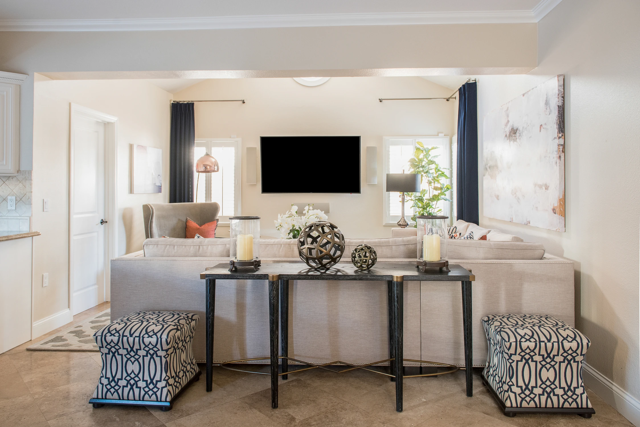 Console table behind cream sofa facing a television wall