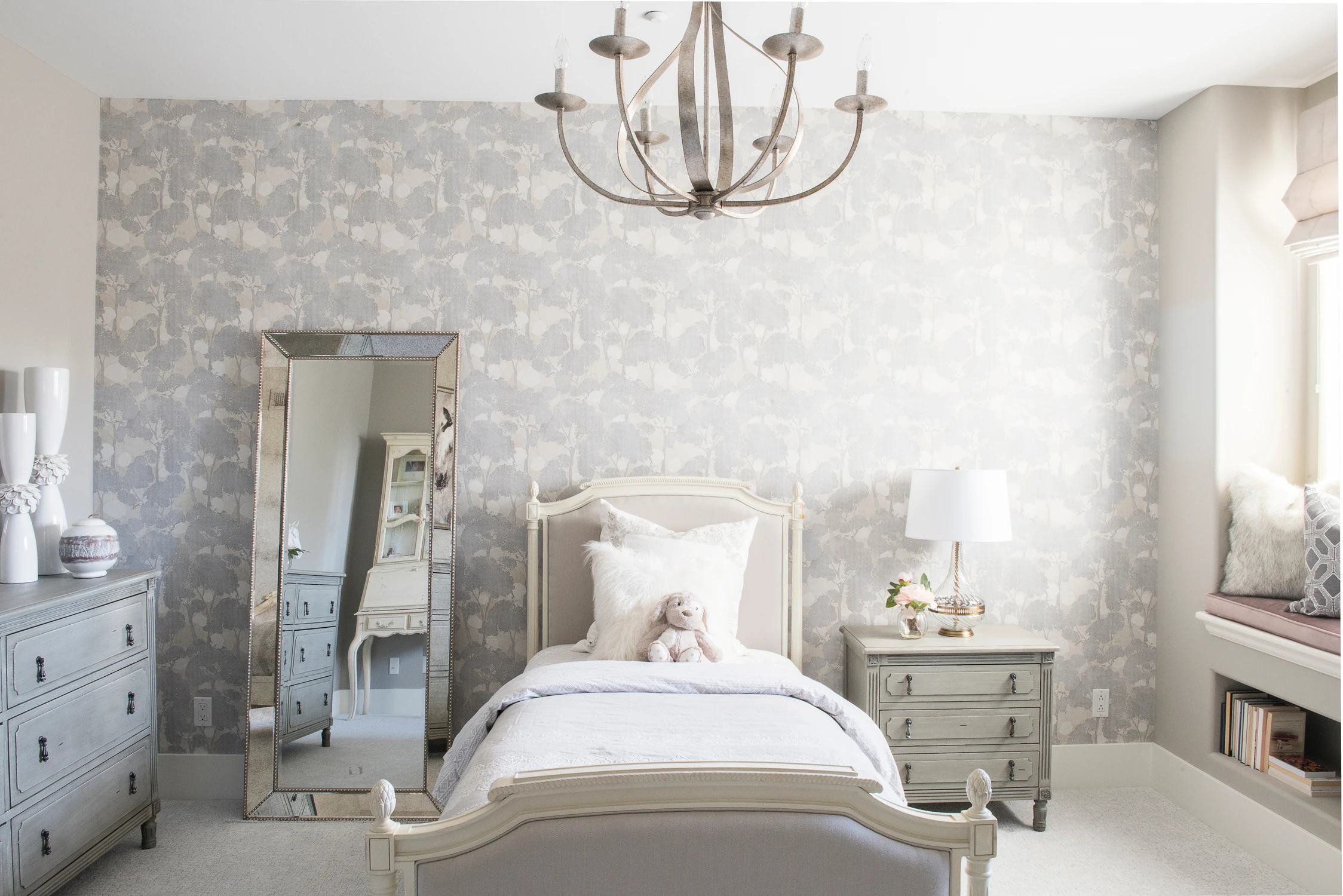 Bedroom view across a pale wood bed and patterned feature wall