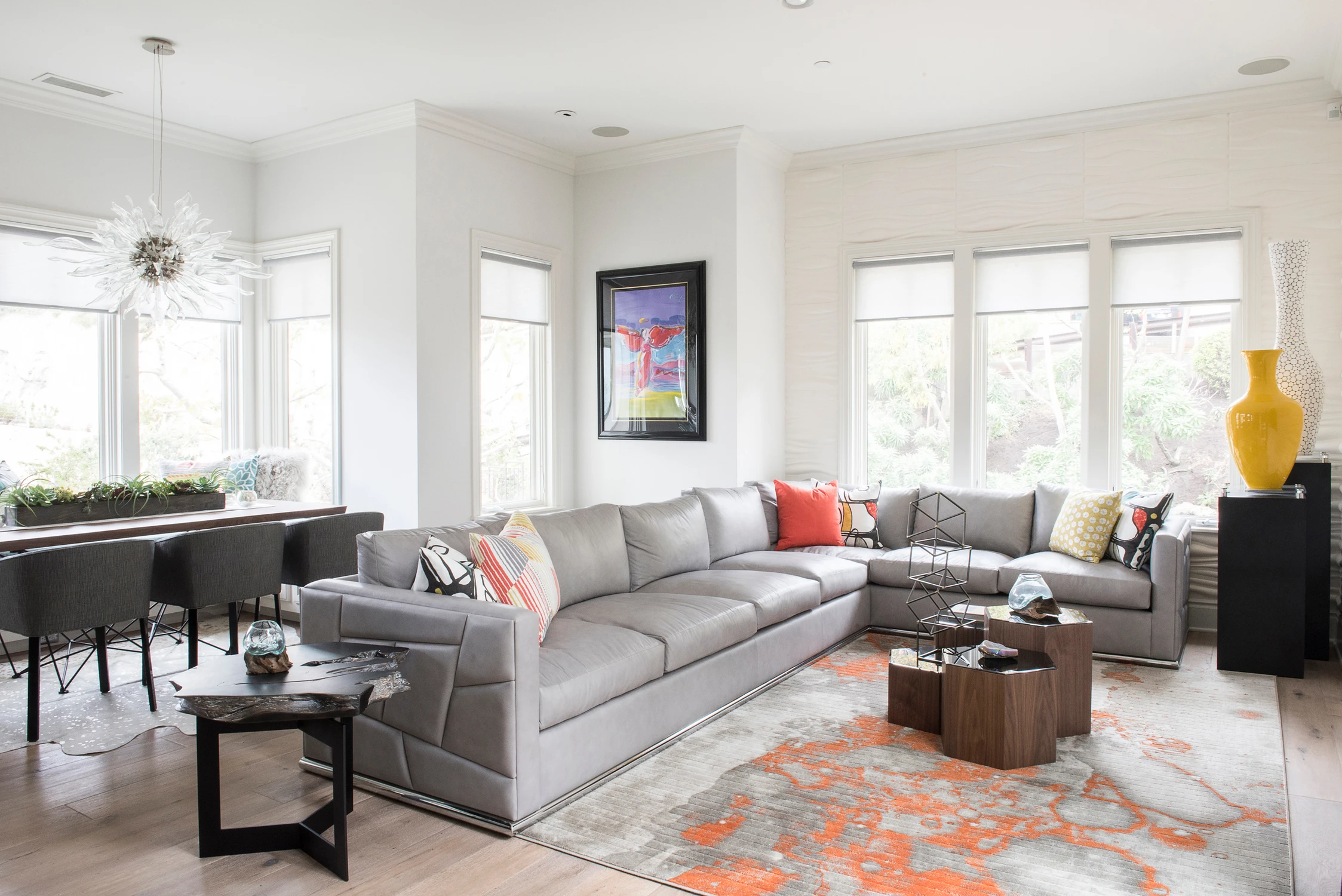 Bright living room with gray sectional, white brick fireplace, and orange rug