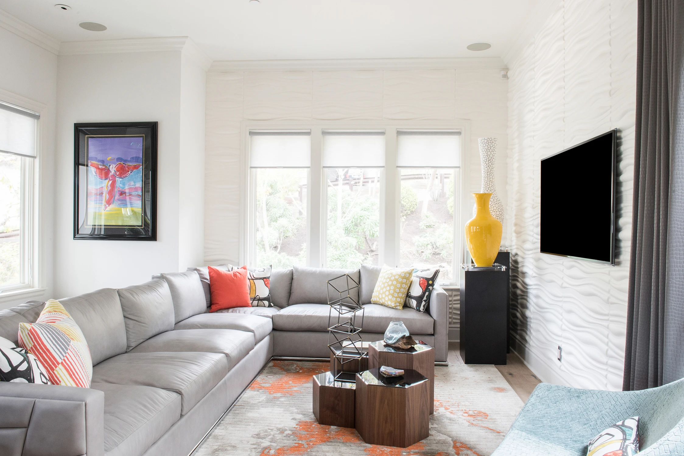 Living room with gray sectional facing a white brick media wall