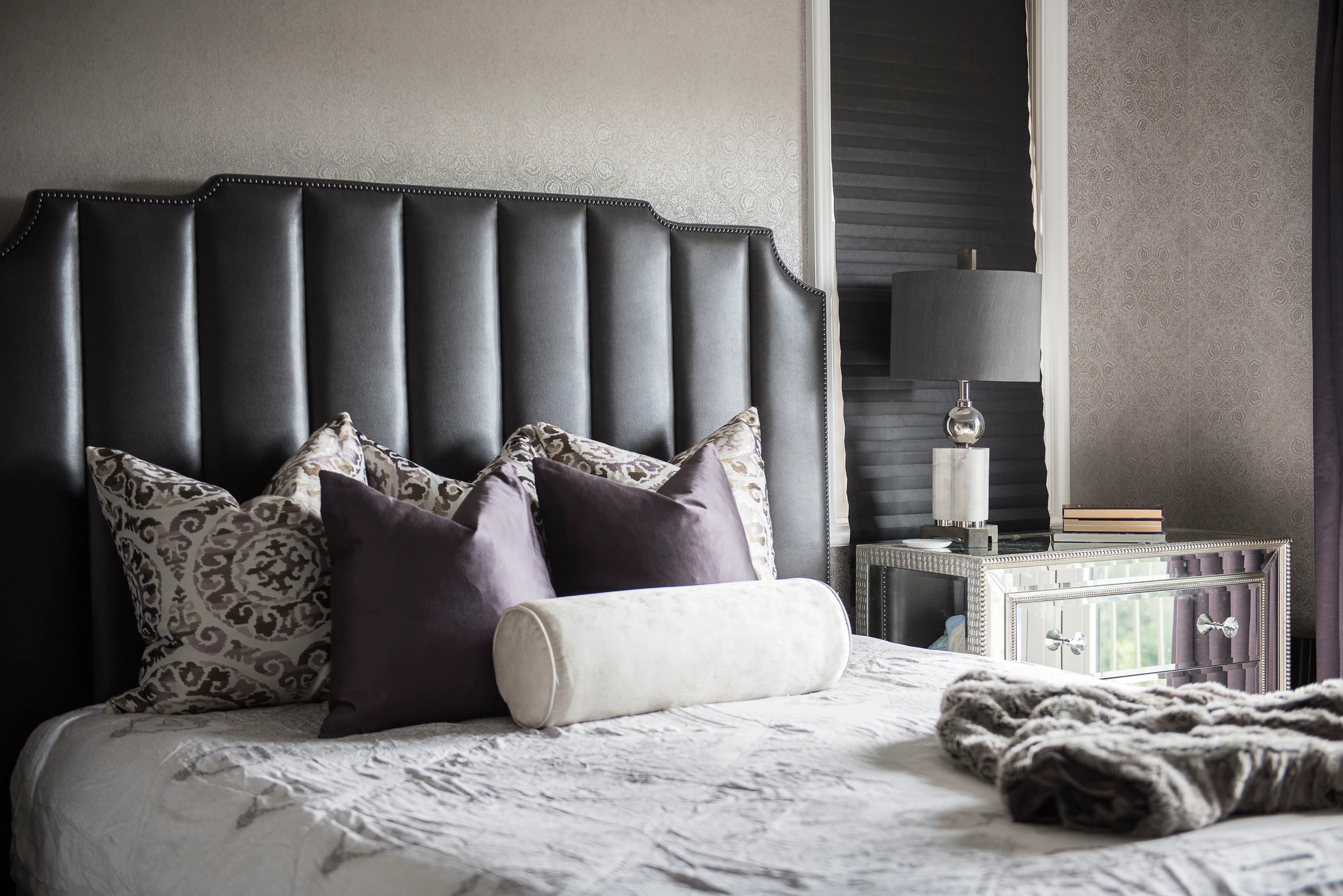 Bedroom with black upholstered headboard and white bedding