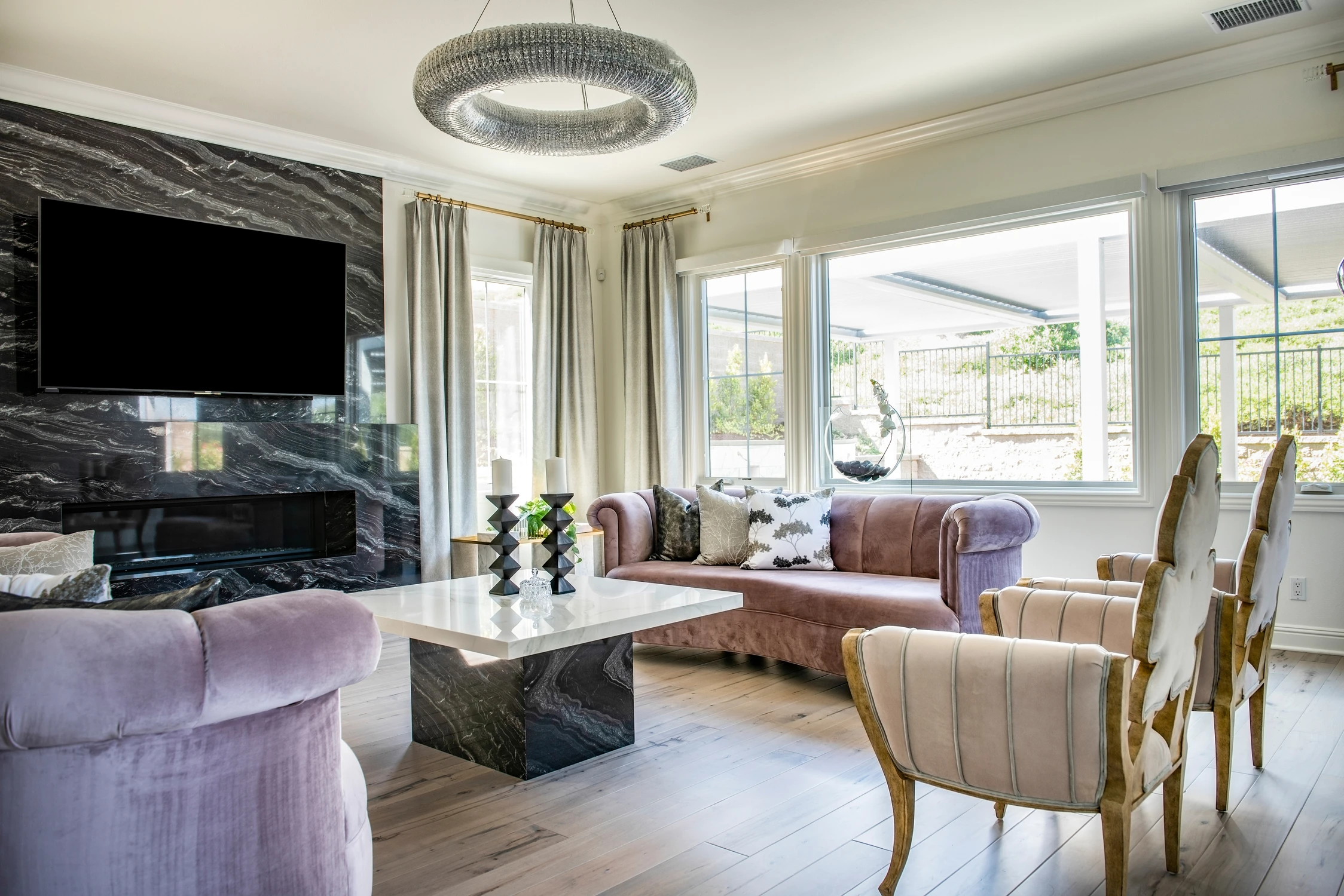 Living room seating facing black marble fireplace and large windows