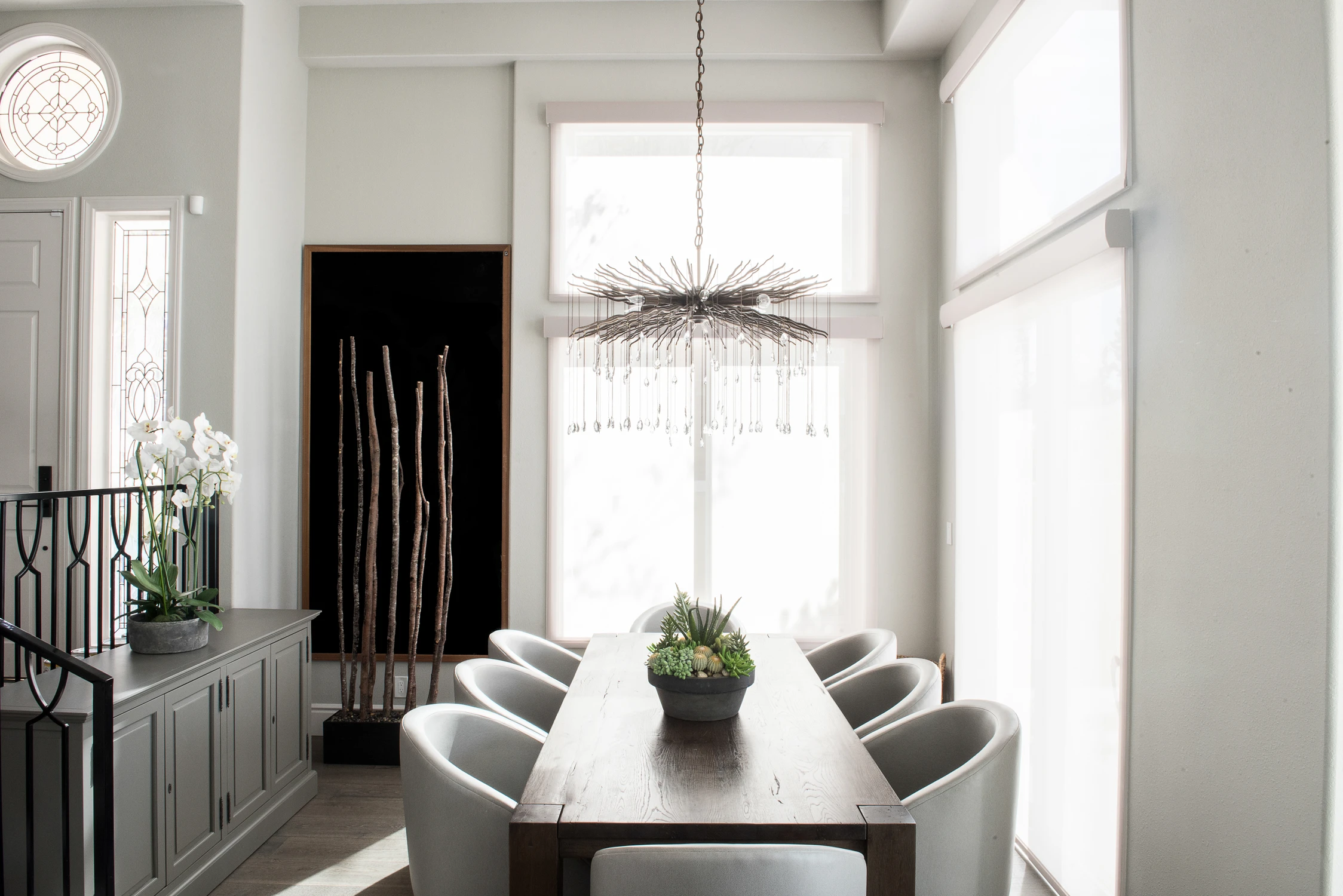 Dining table beside black wall panels and open stair railing