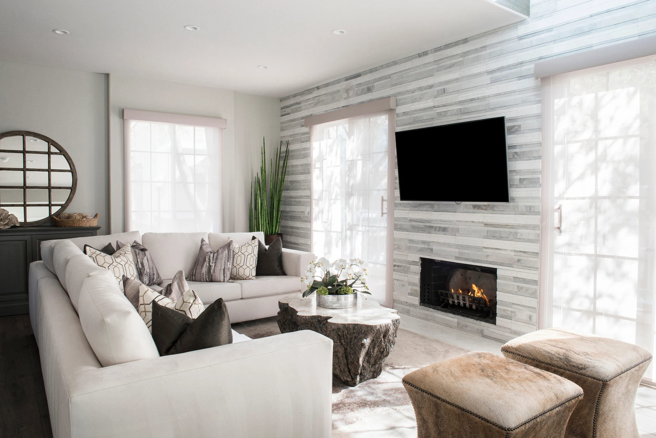 Living room with white sofas, fireplace, and wall-mounted television