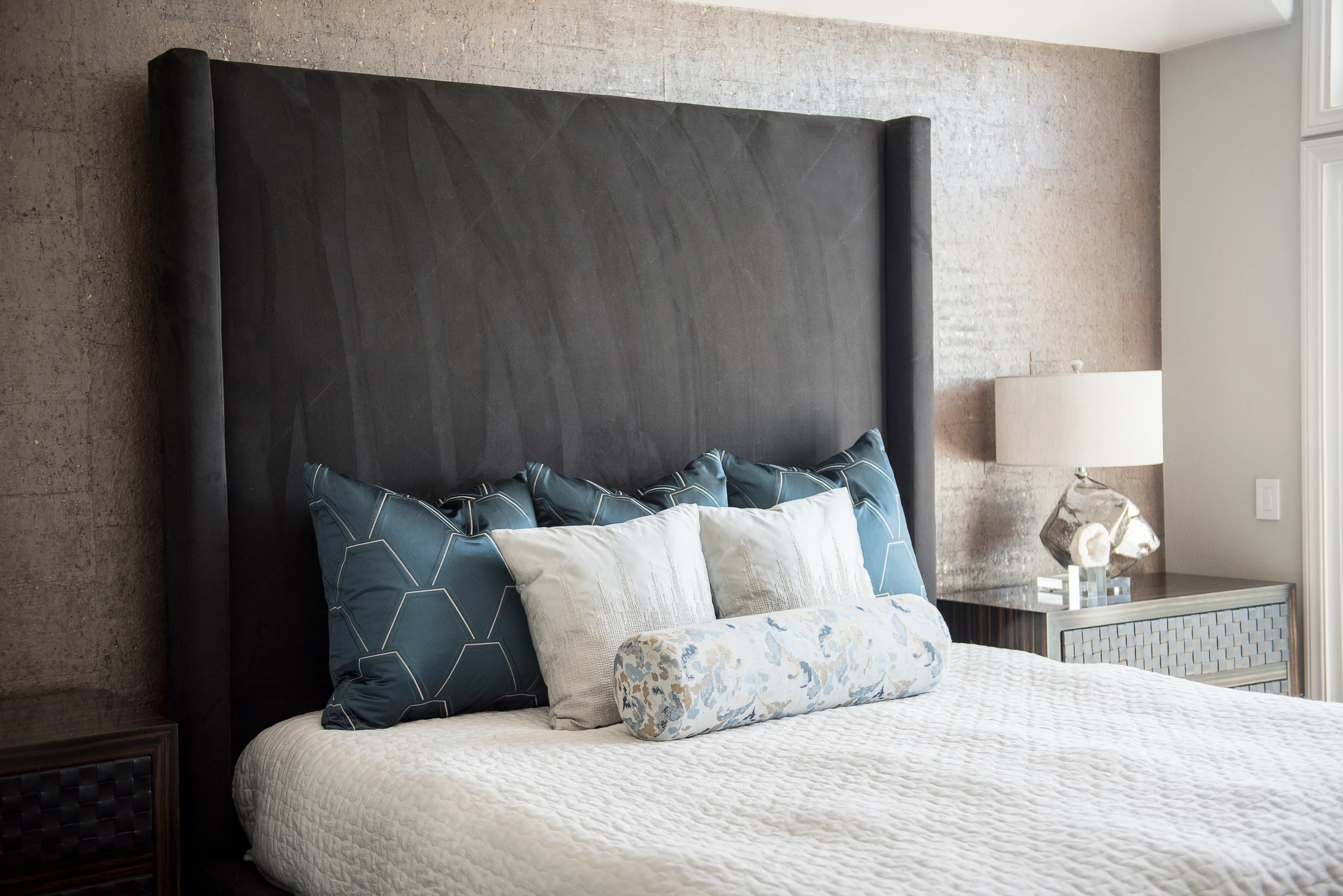 Bedroom with dark upholstered headboard and white bedding