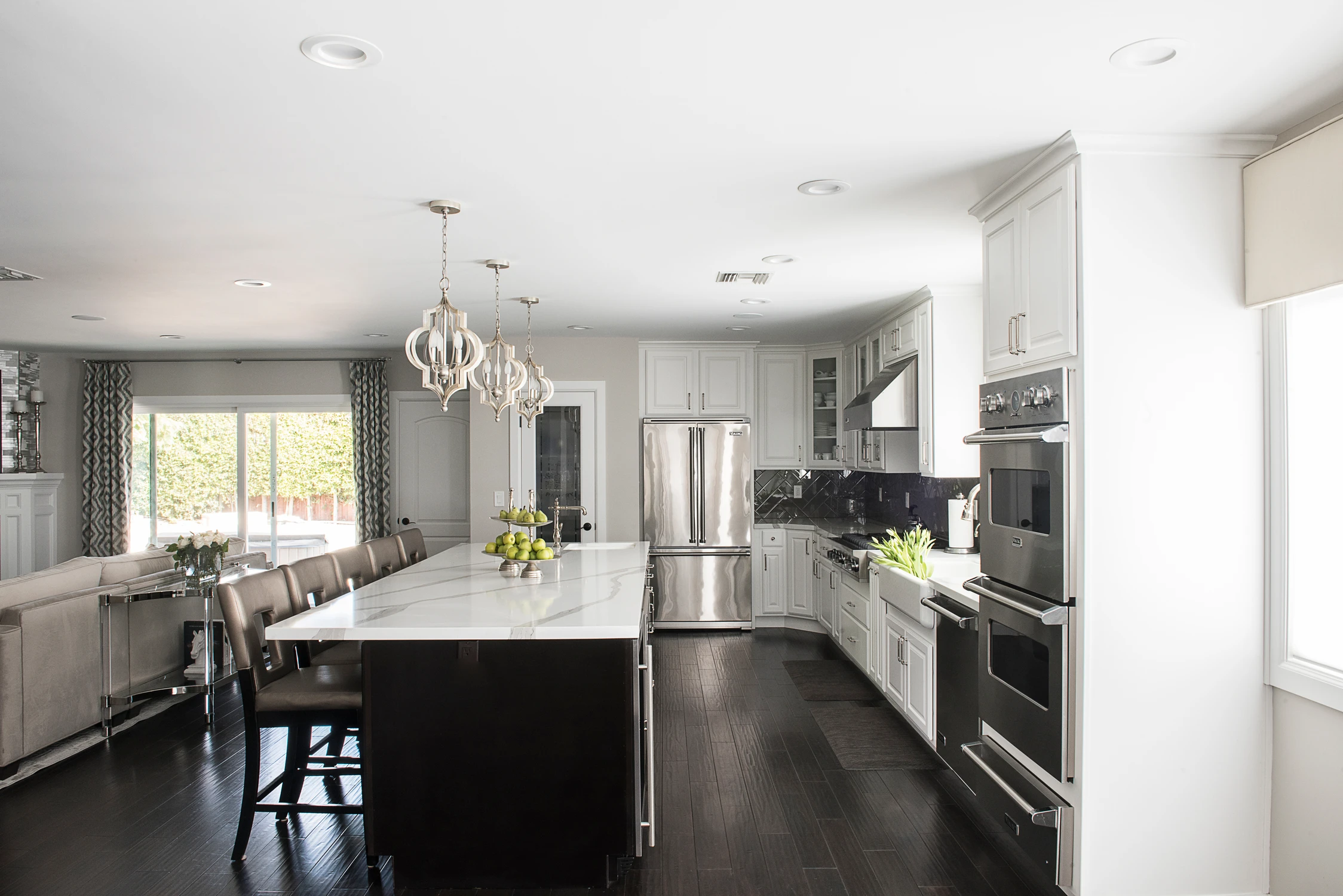 White kitchen with dark island and glass globe chandelier