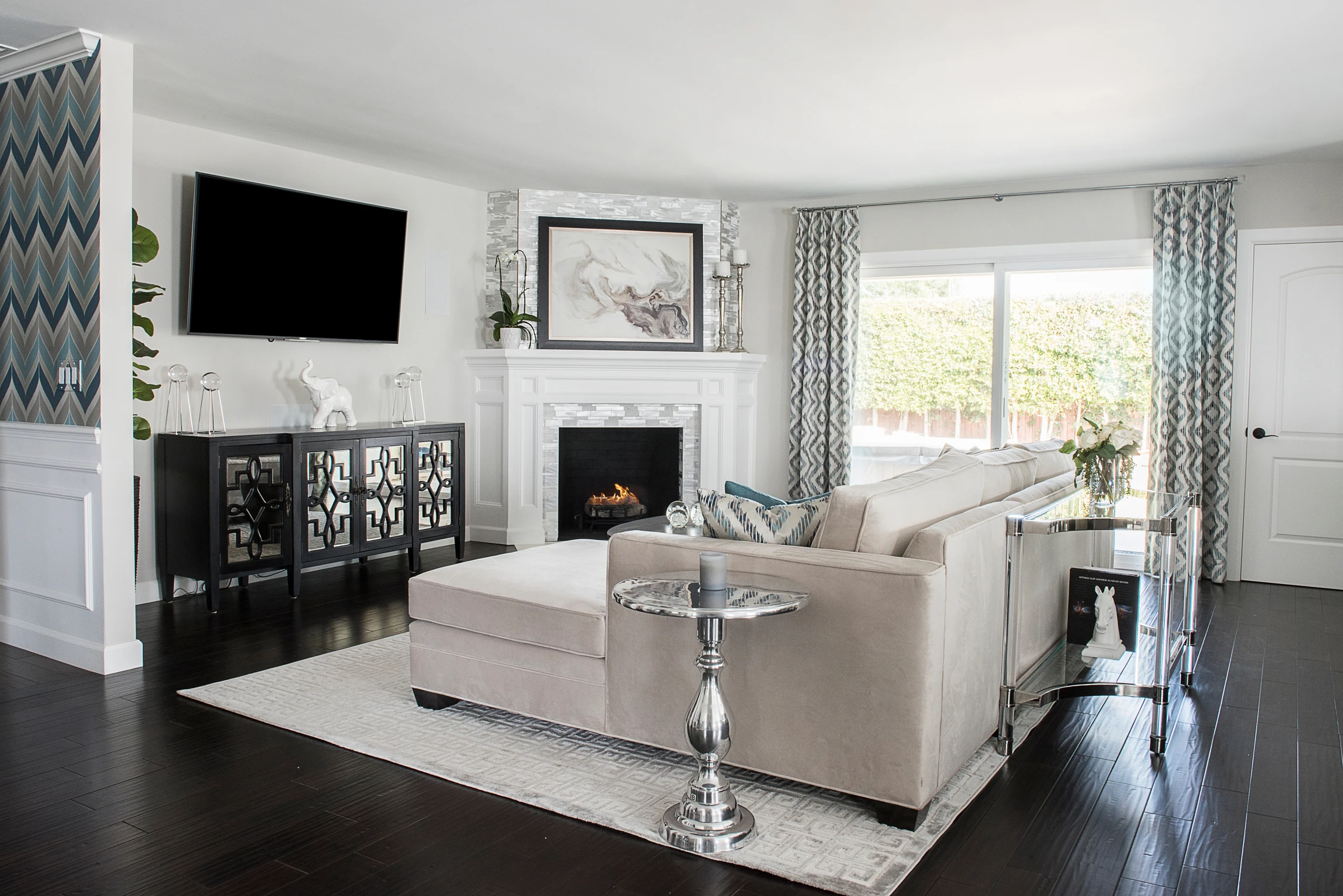 Living room fireplace framed by black built-ins and white mantel