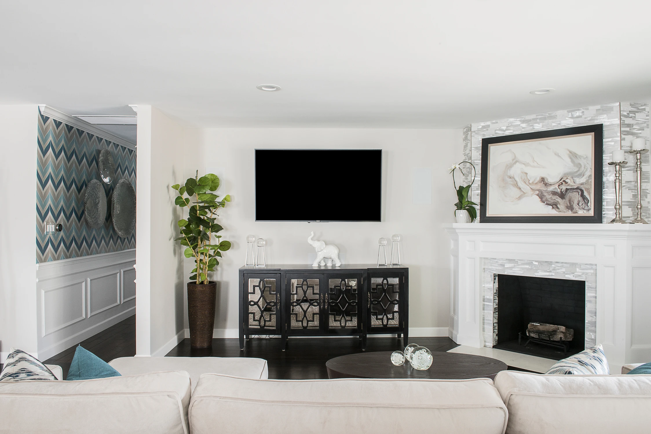 Television wall above black console cabinet and fireplace