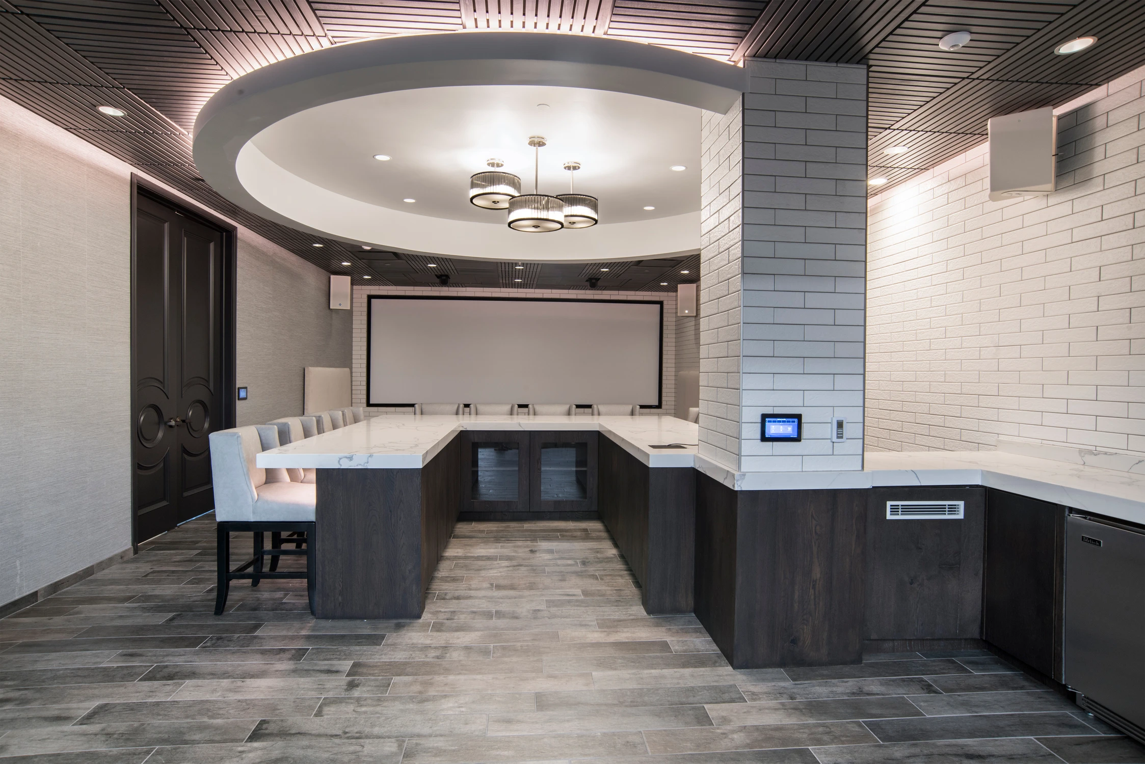 Table beneath circular recessed ceiling and white brick walls