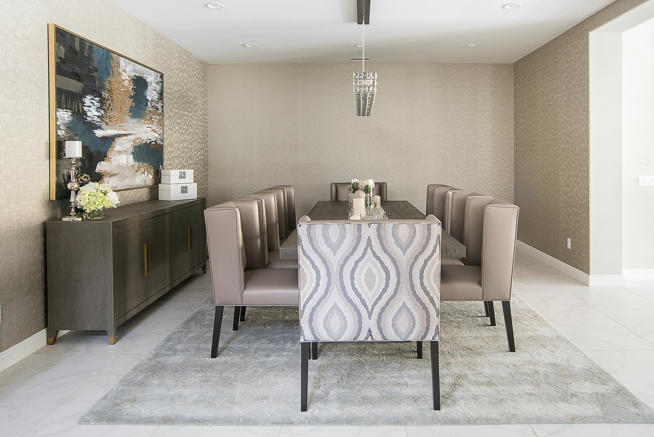 Dining room with patterned host chairs, neutral walls, and linear pendant