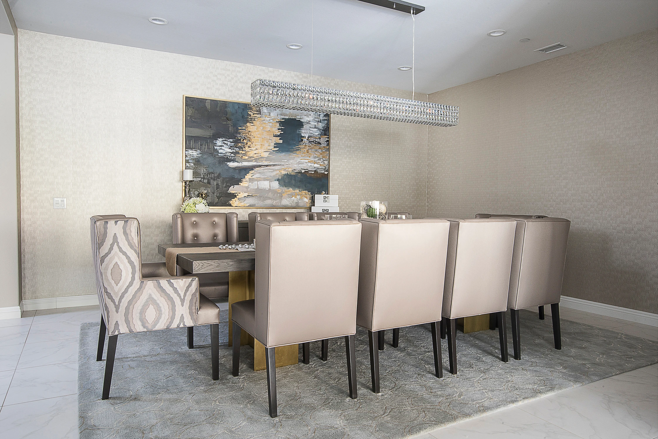 Dining table viewed across upholstered chairs and textured wall covering
